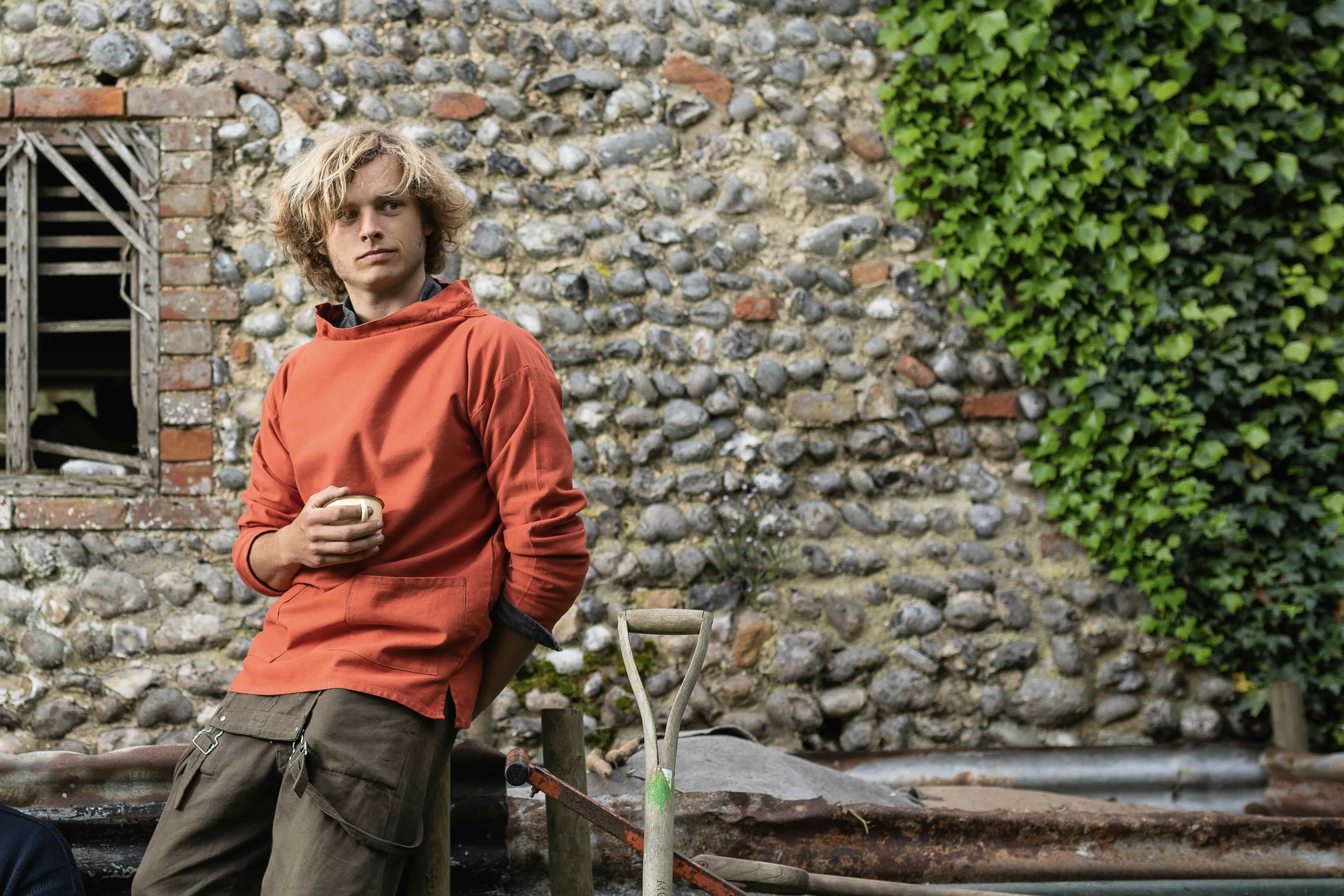 Man standing in field of corn wearing Carrier Company Work jacket in Navy Cotton Drill