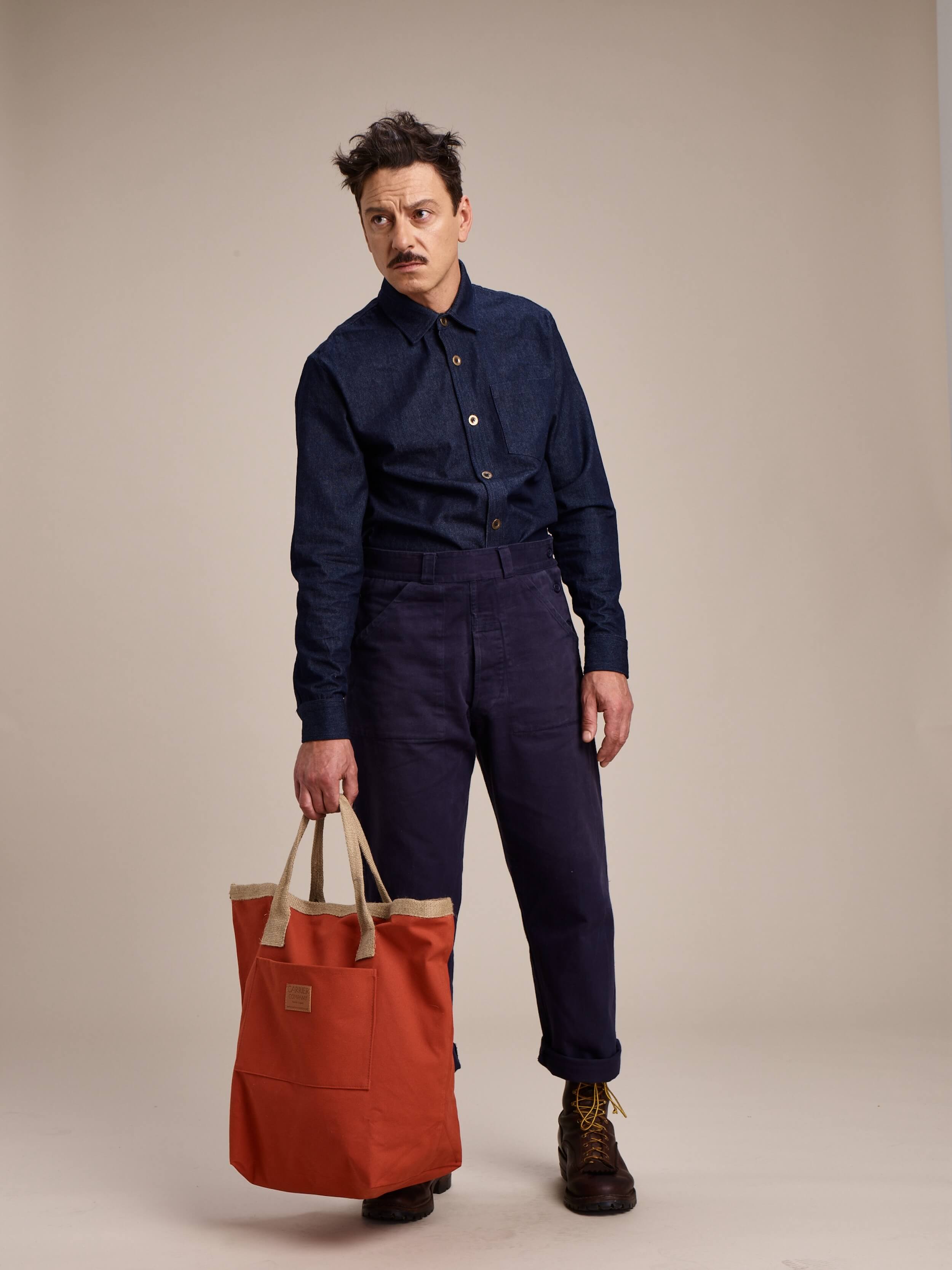 Enzo wears Carrier Company Denim Collar Shirt with Half Apron and Men's Work Trouser
