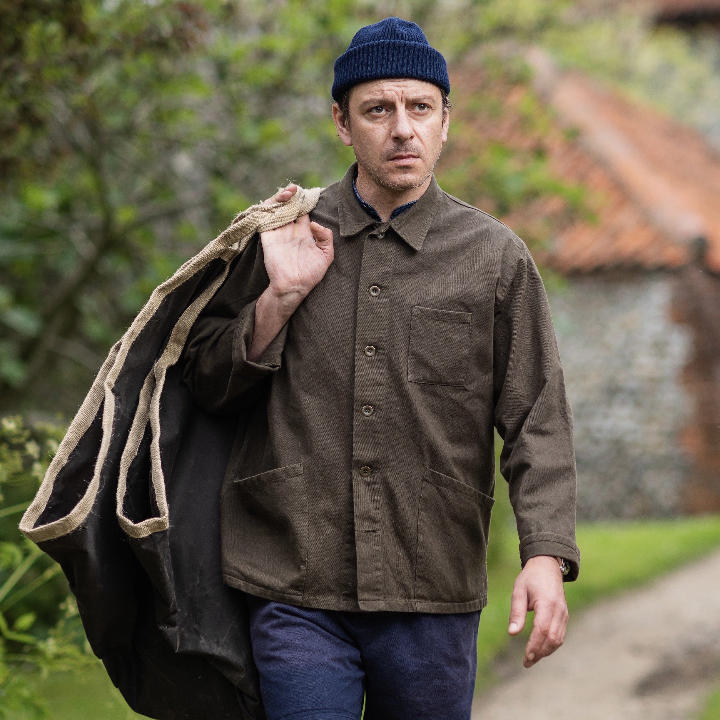 Man wears Traditional Work Jacket in Olive and Wool Hat in Navy