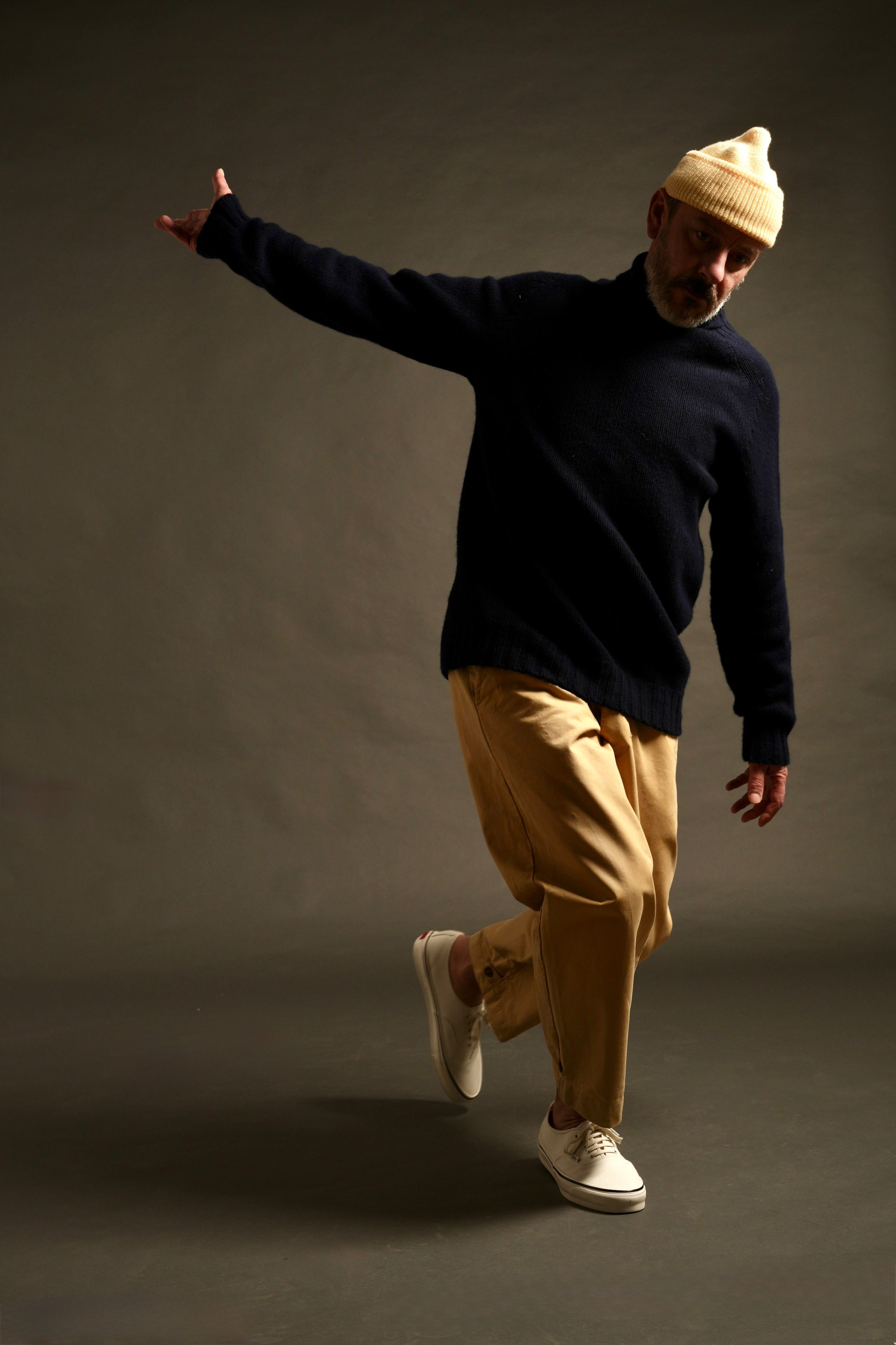 Enzo wears Navy Rollneck Supersoft Shetland jumper with Mortimer Trouser and Merino Watch Cap in Guava.