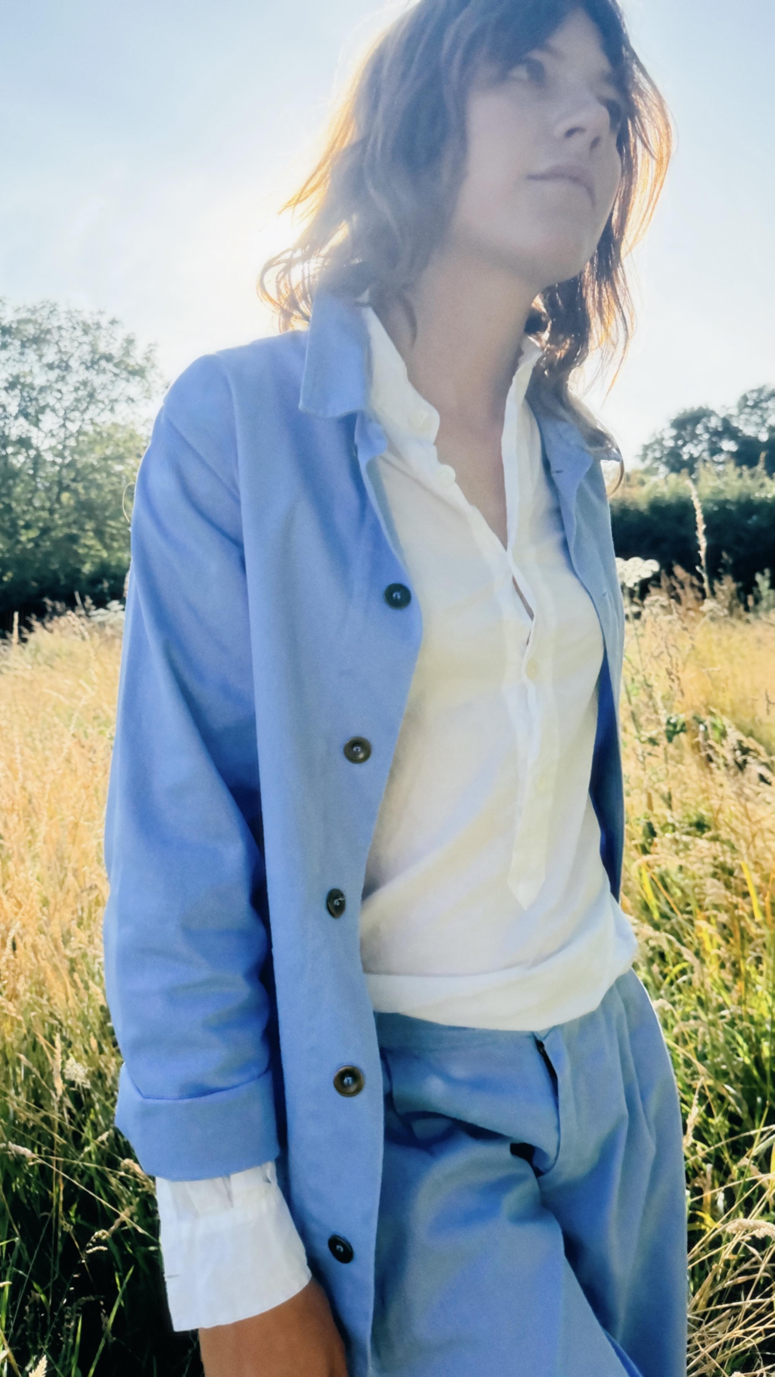 Minna wears Carrier Company Norfolk Work Jacket in Powder Blue with Lightweight Collarless Shirt and Dutch Trousers in Powder Blue