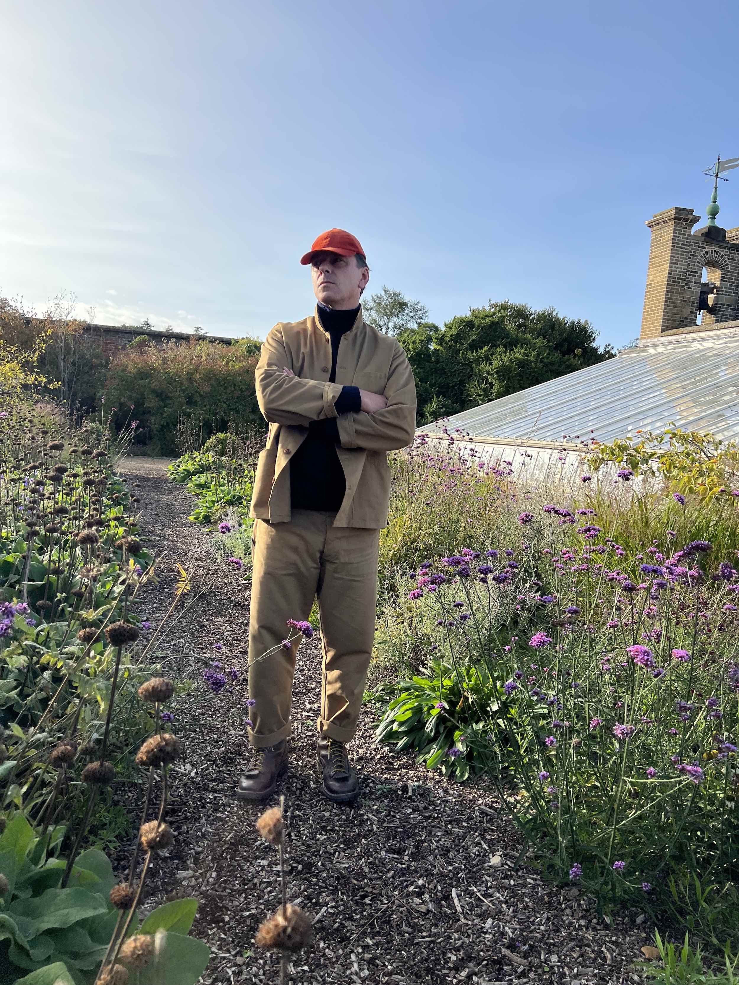 Enzo wears Carrier Company Merino & Cashmere Supersoft Roll Neck Jumper with Tan Norfolk Work Jacket and Corduroy Cap