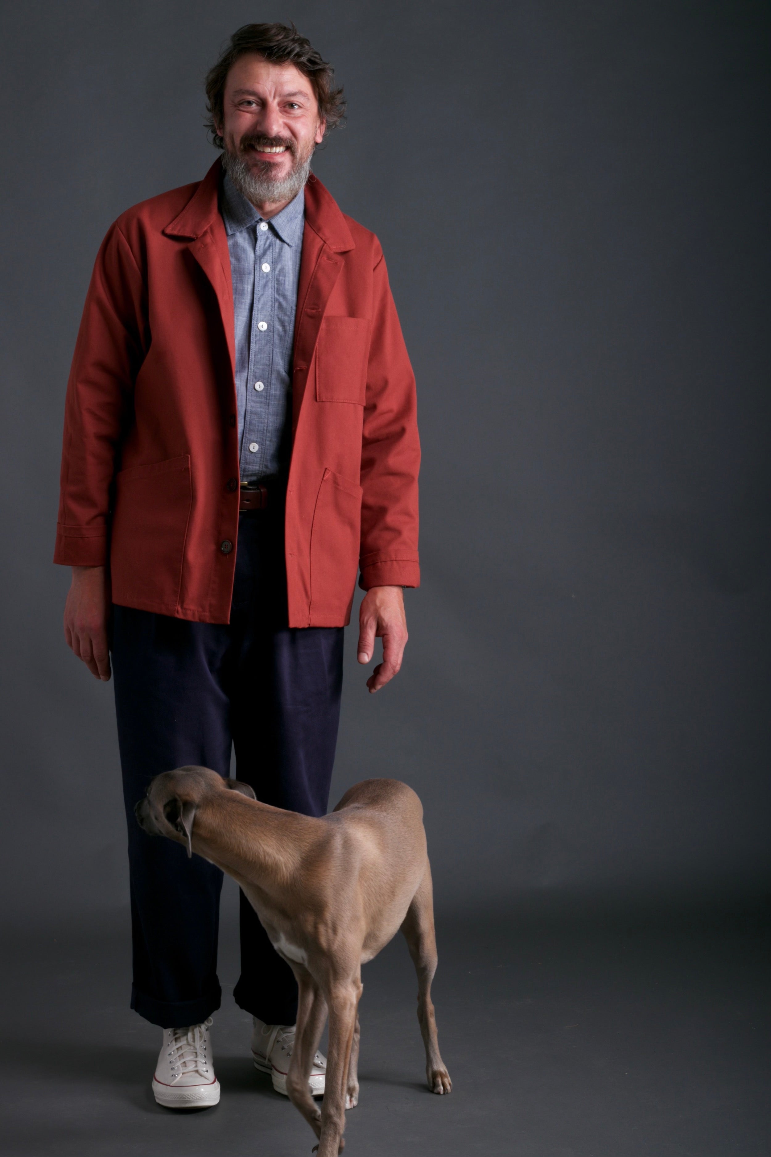 Man wears Carrier Company Traditional Work Jacket in Breton with Chambray Shirt and Classic Trouser in Navy
