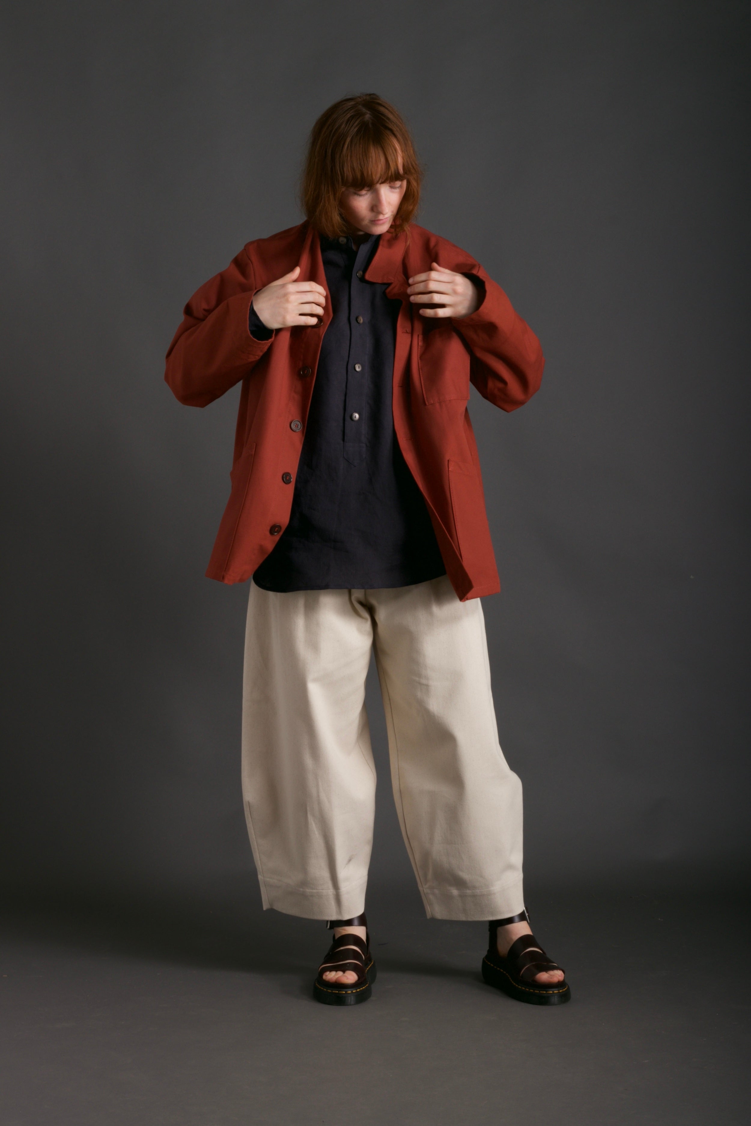 Woman wears Norfolk Work Jacket in Breton with Navy Linen Collarless Shirt and Dutch Trouser in Seeded Denim