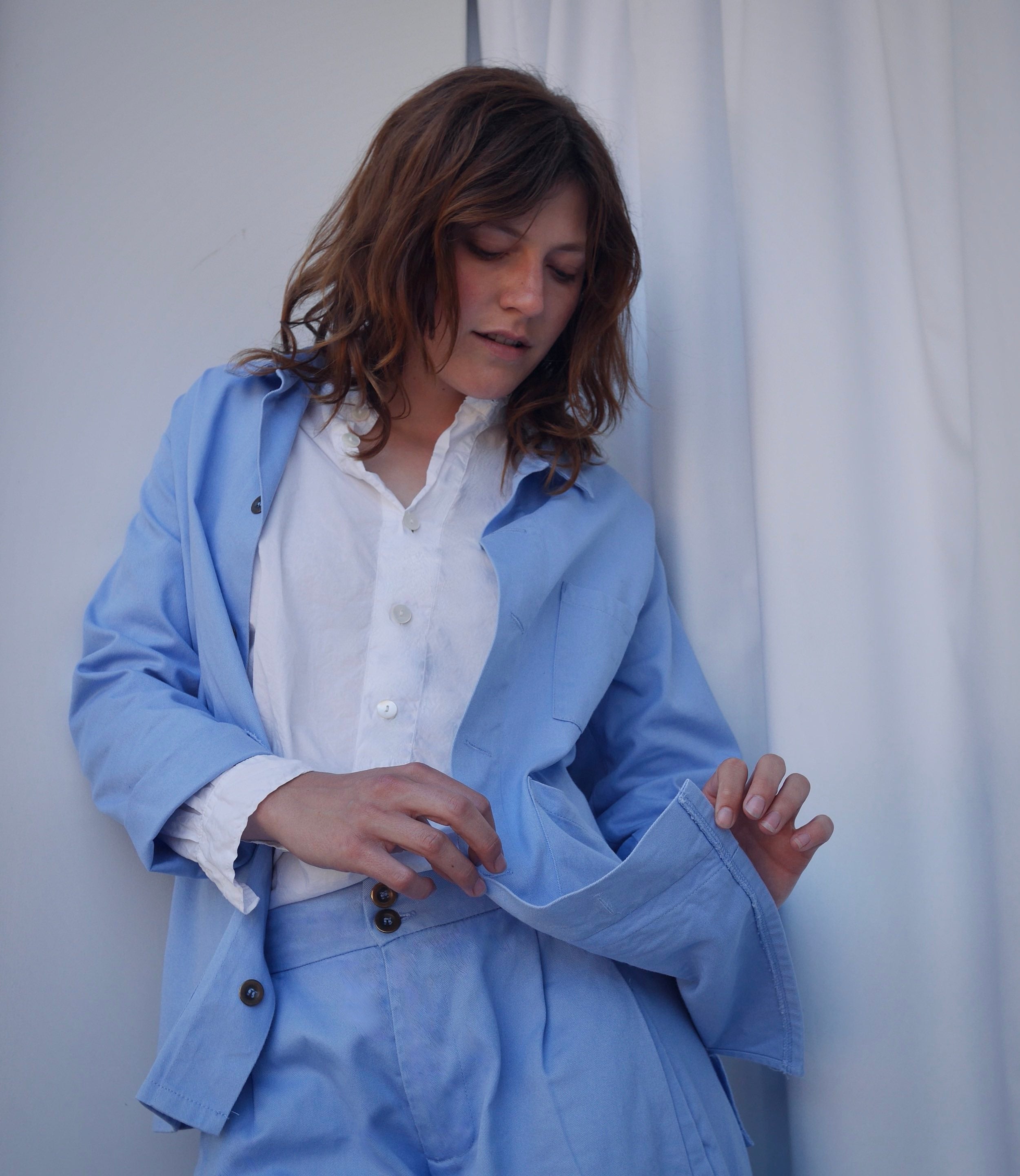 Minna wears Carrier Company Norfolk Work Jacket in Powder Blue with Lightweight Collarless Shirt and Dutch Trousers in Powder Blue