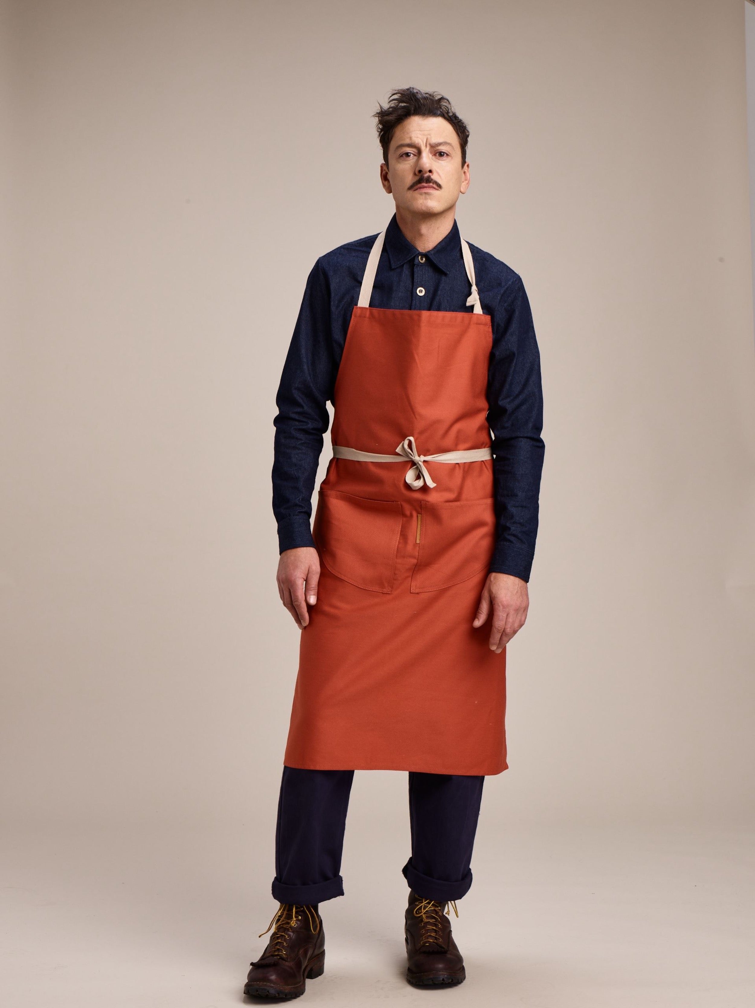 Man wears Carrier Company Long Apron in Orange