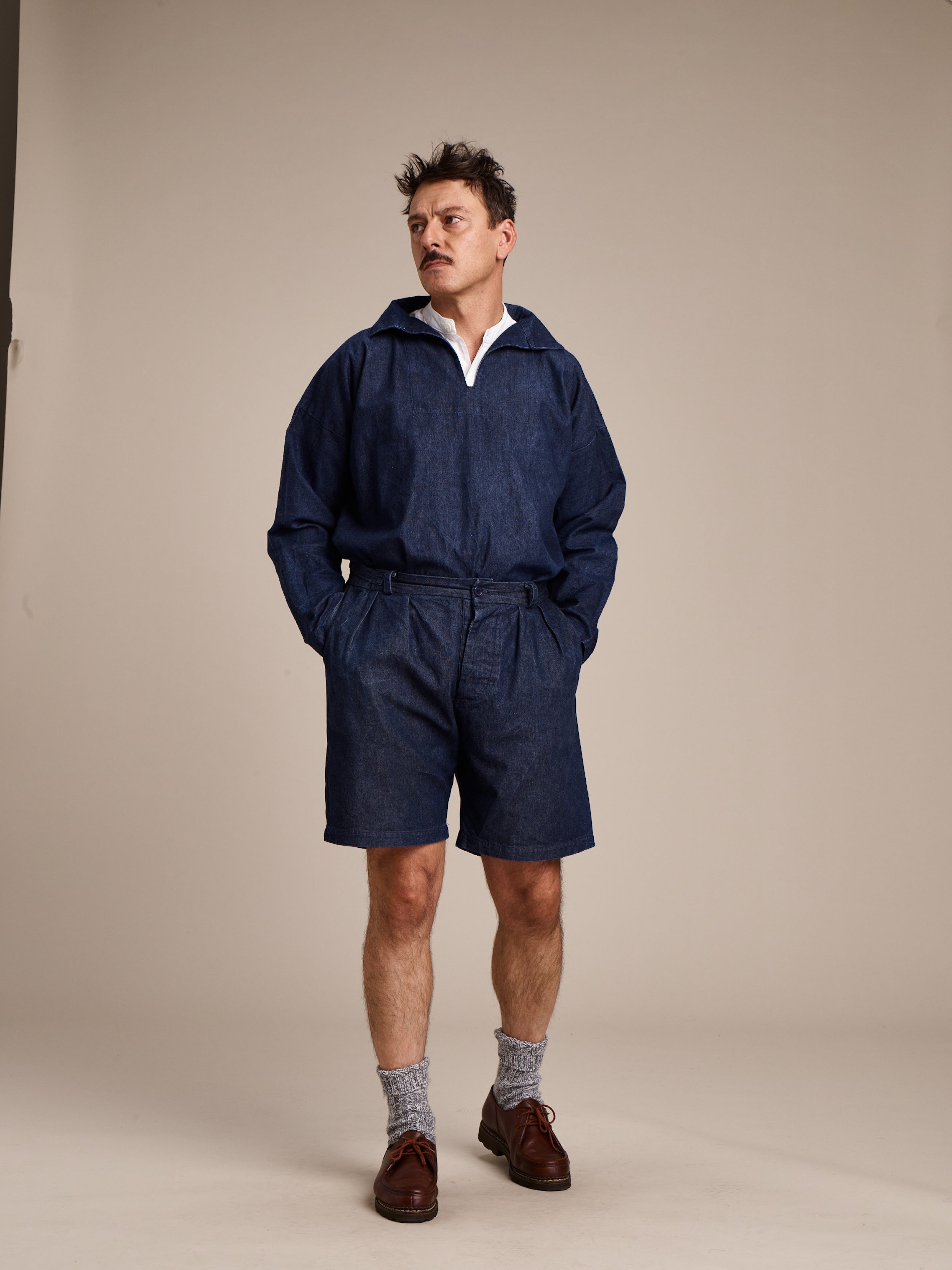 Man wearing Carrier Company V-Neck Smock in Denim and Denim Grandpa Shorts