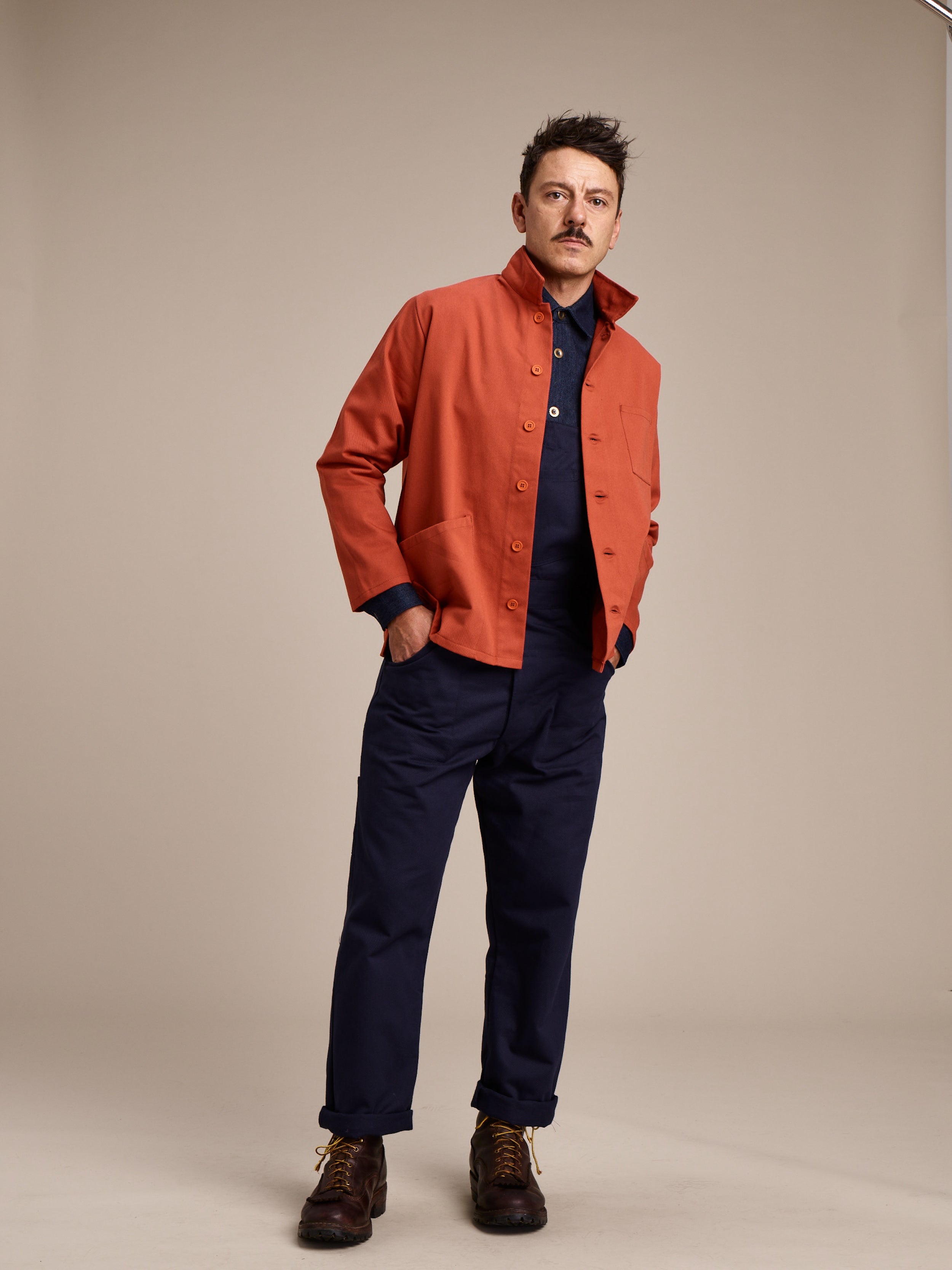 Man wearing Carrier Company Norfolk Work Jacket in Orange with Denim Collared Shirt and Men's Work Trouser