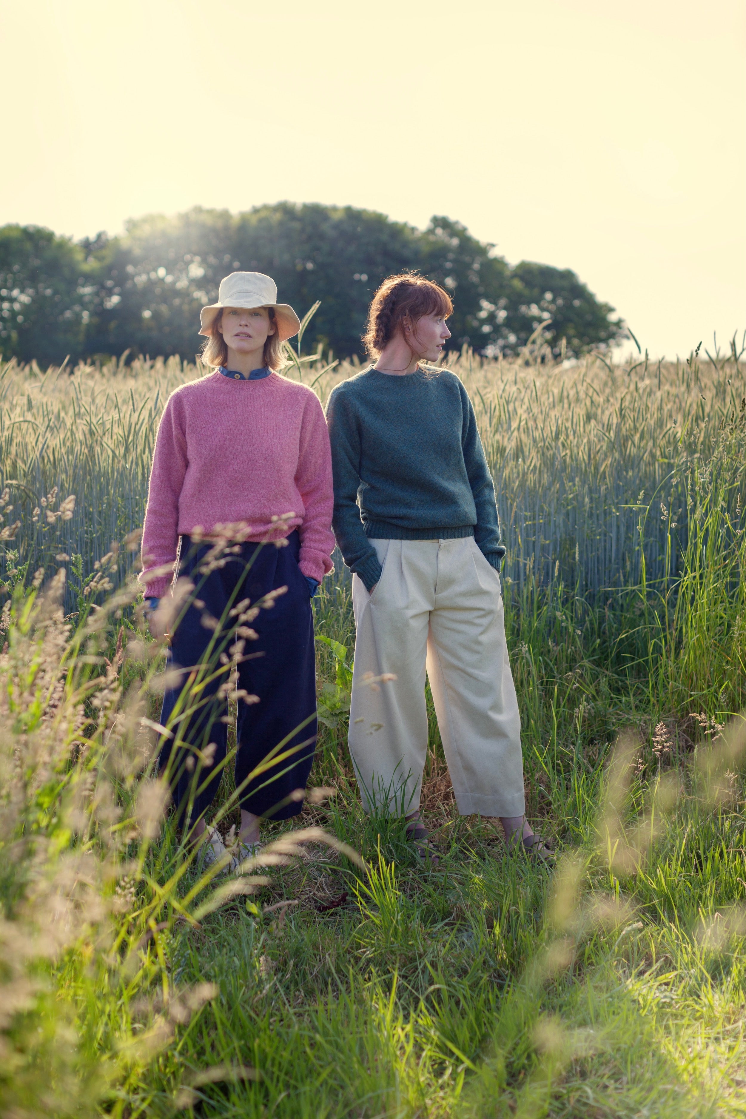 Woman wears Carrier Company Shetland Lambswool Jumper in Salmon with Dutch Trouser in Navy Drill