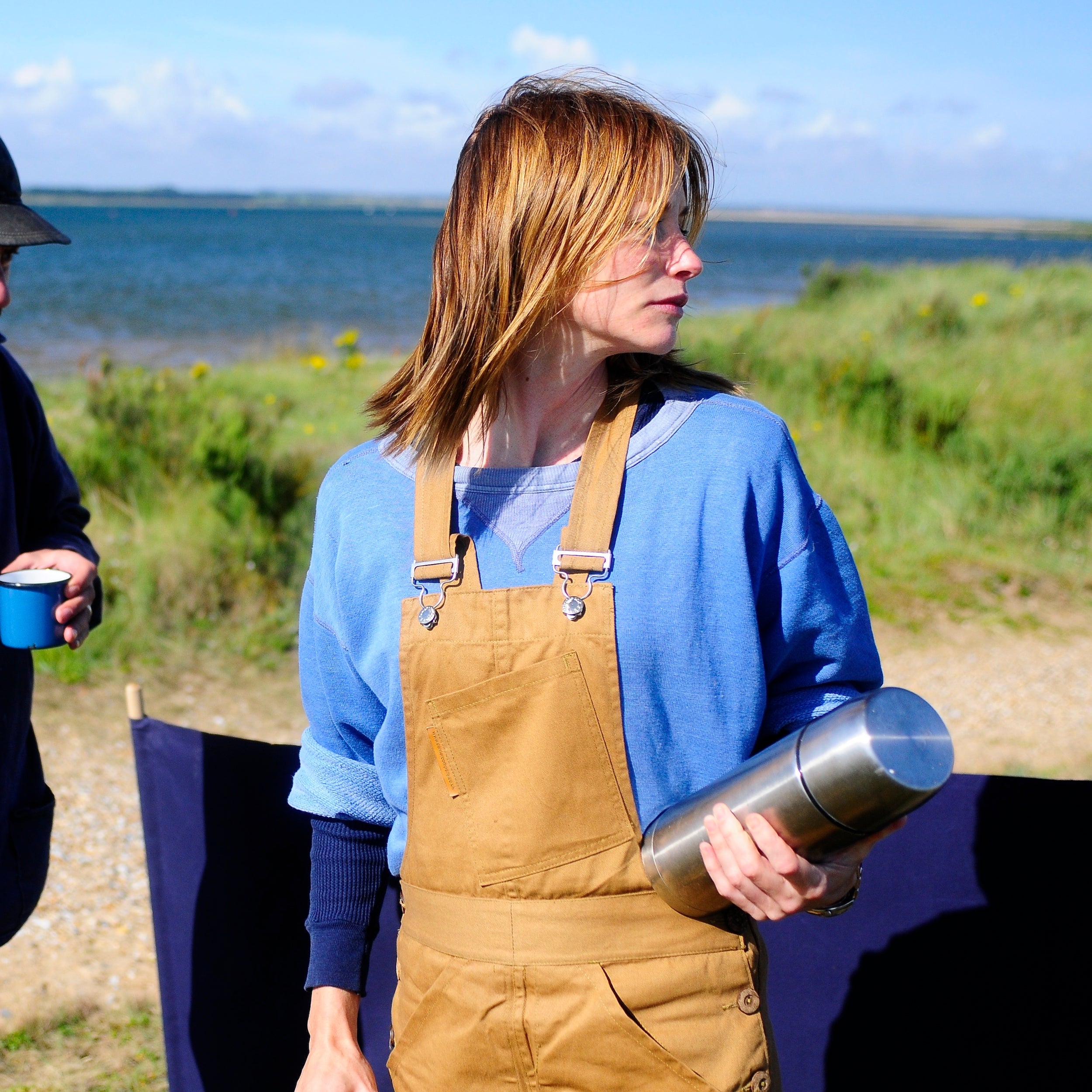 Woman wears Carrier Company Women's Dungarees in Tan