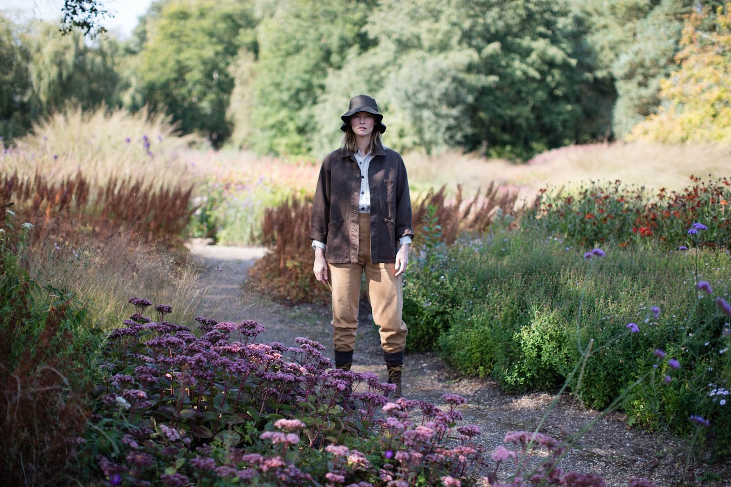 Woman wears  Carrier Company Waxed Cotton Hat in Olive with Olive Work Jacket and Tan Work Trousers