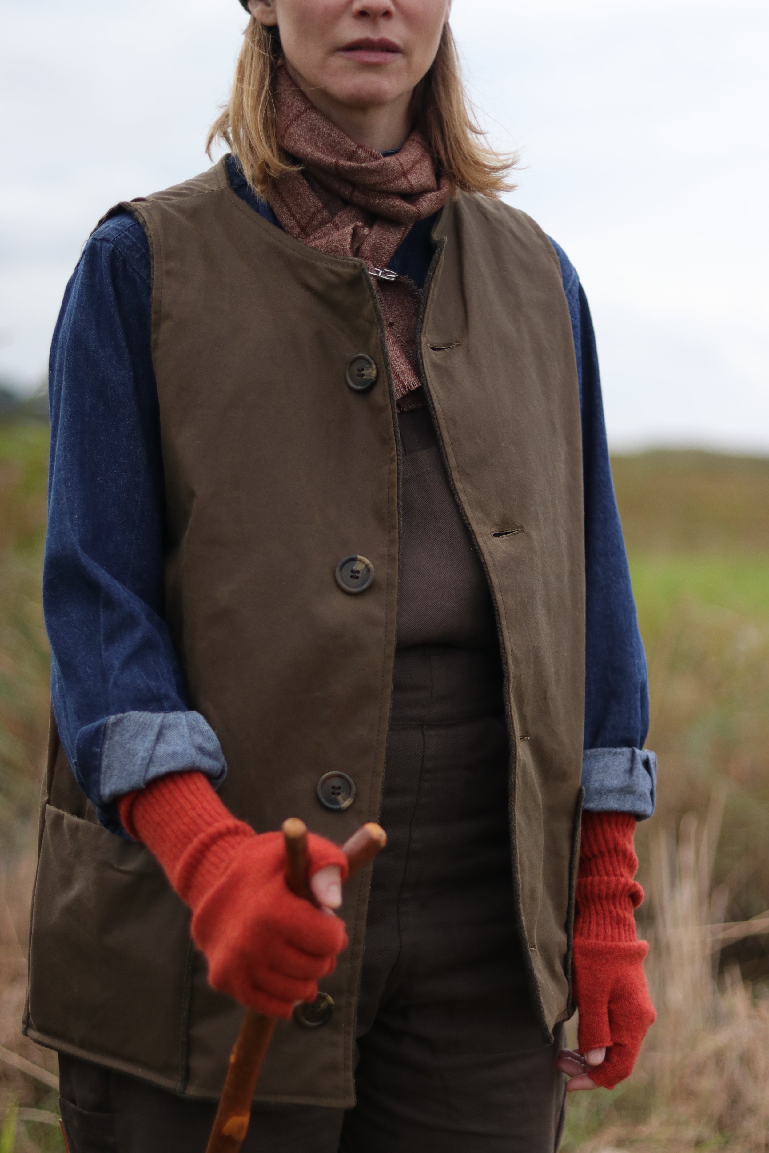 Woman wearing Carrier Company Norfolk Jerkin in Tan with Olive Women's Dungarees and Denim Work Shirt