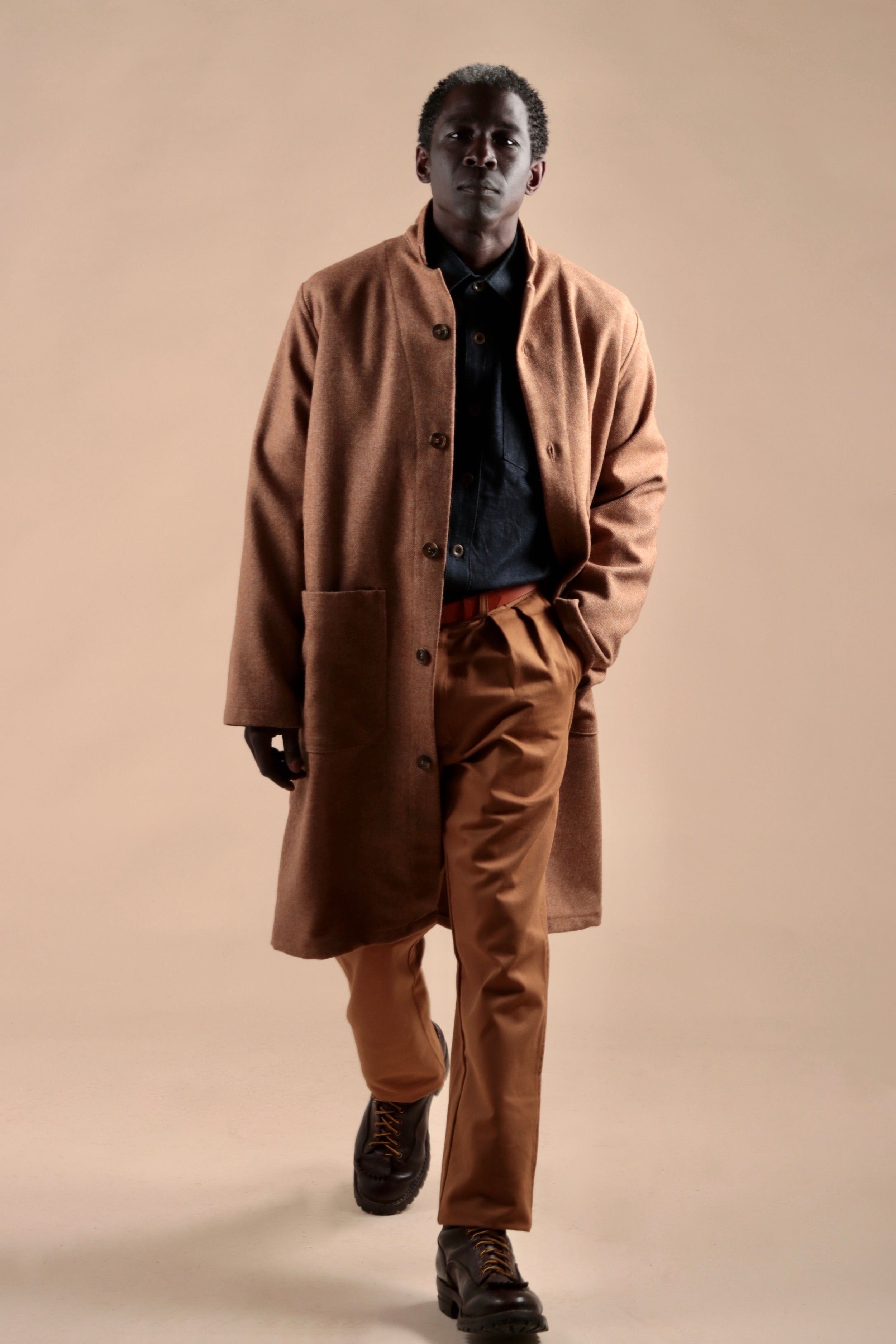 Man wears Carrier Company Tan Herringbone Wool Coat with Classic Trouser and Denim Collar Shirt