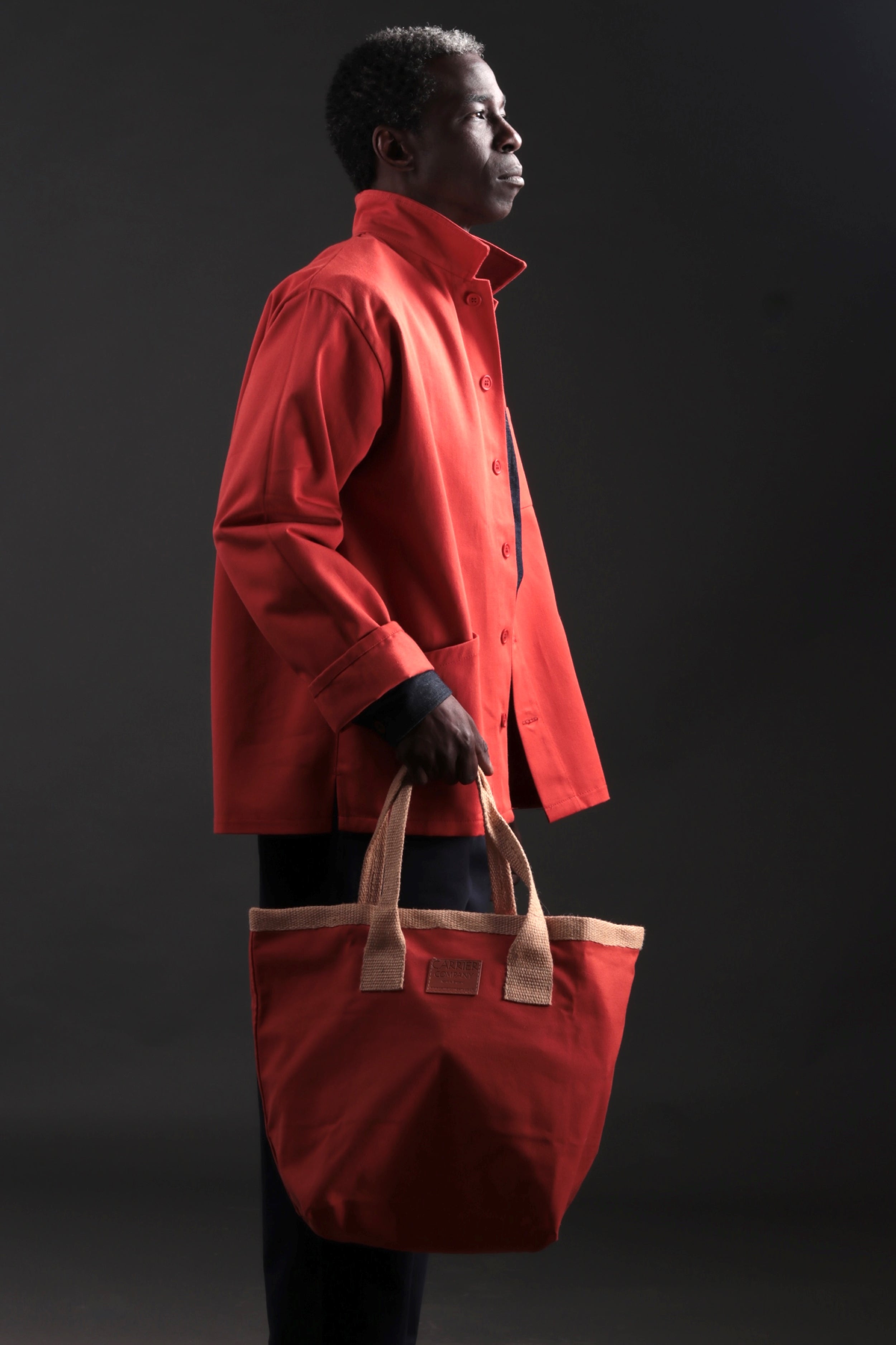 Man Carries Carrier Company Sturdy Bag in Orange