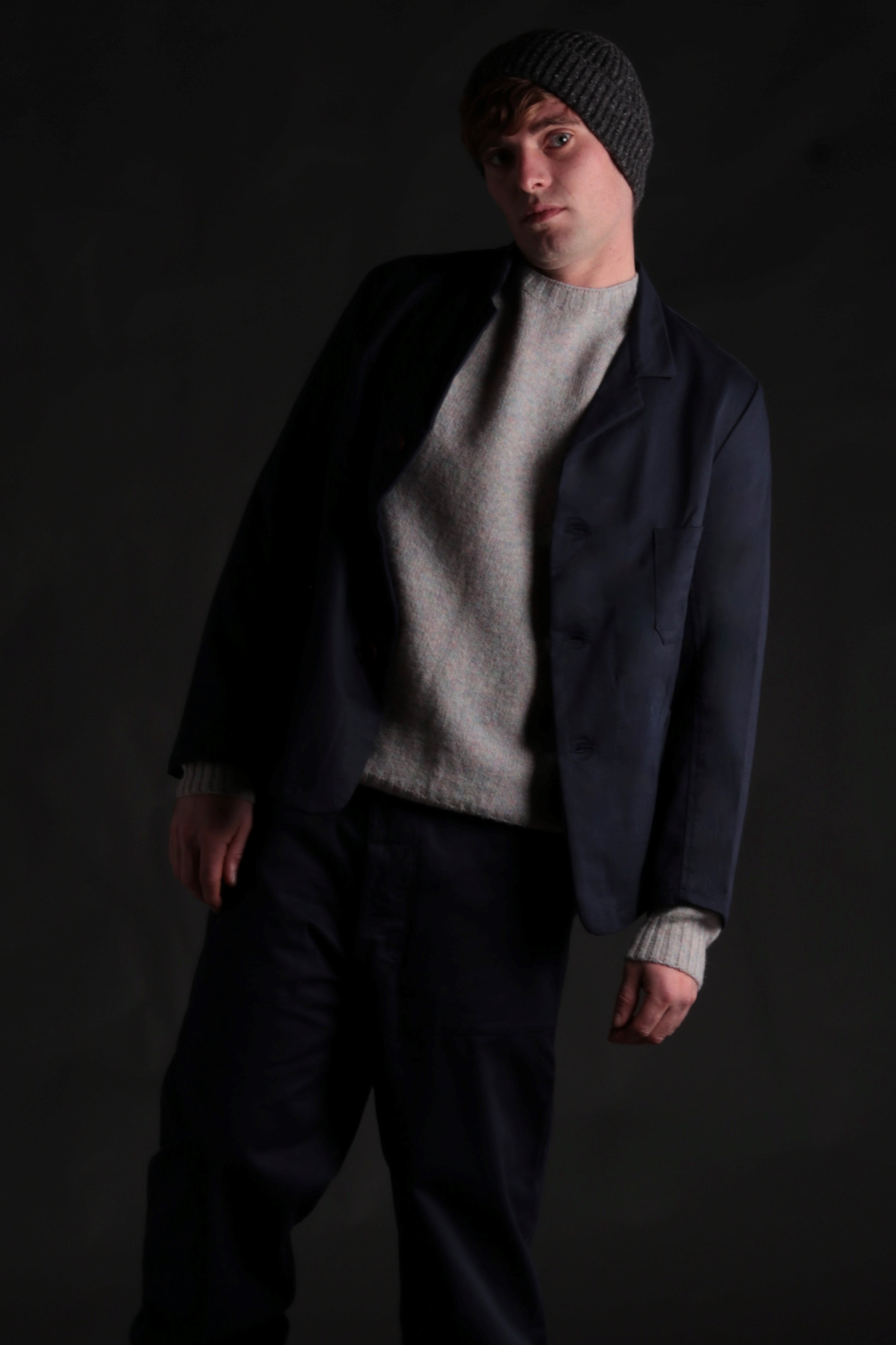 Man wears Carrier Company 3 Button Jacket in Navy Drill with Shetland Lambswool Jumper and Merino Wool Hat