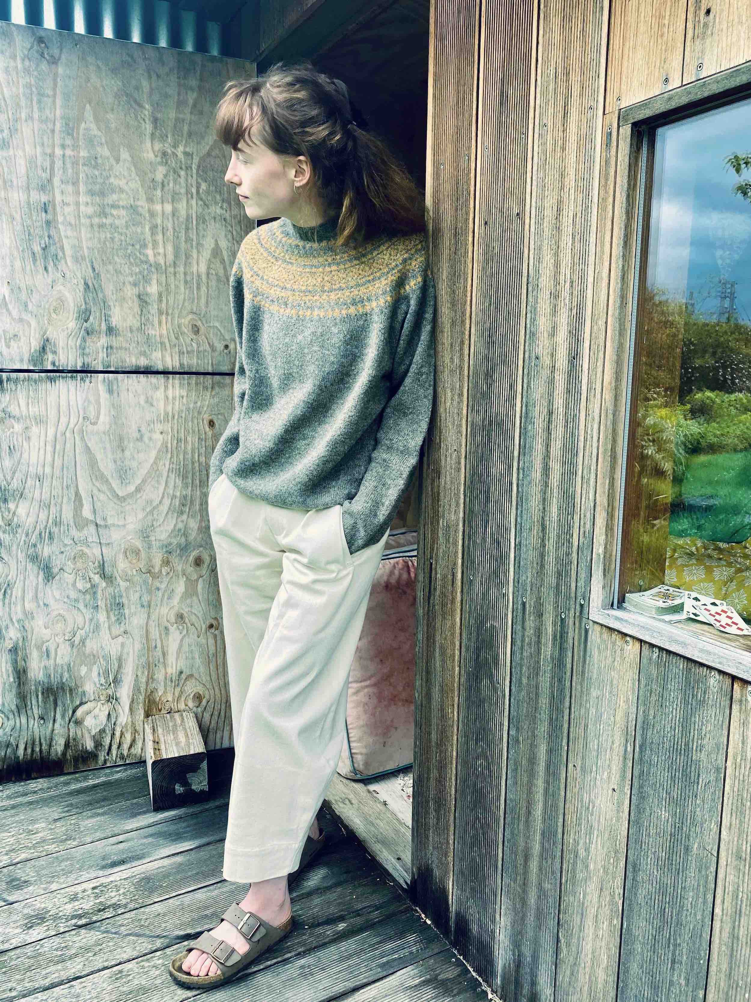 Woman wears Carrier Company Yoke Shetland Lambswool Jumper in Oyster & Cumin and Dutch Trouser in Seeded Denim