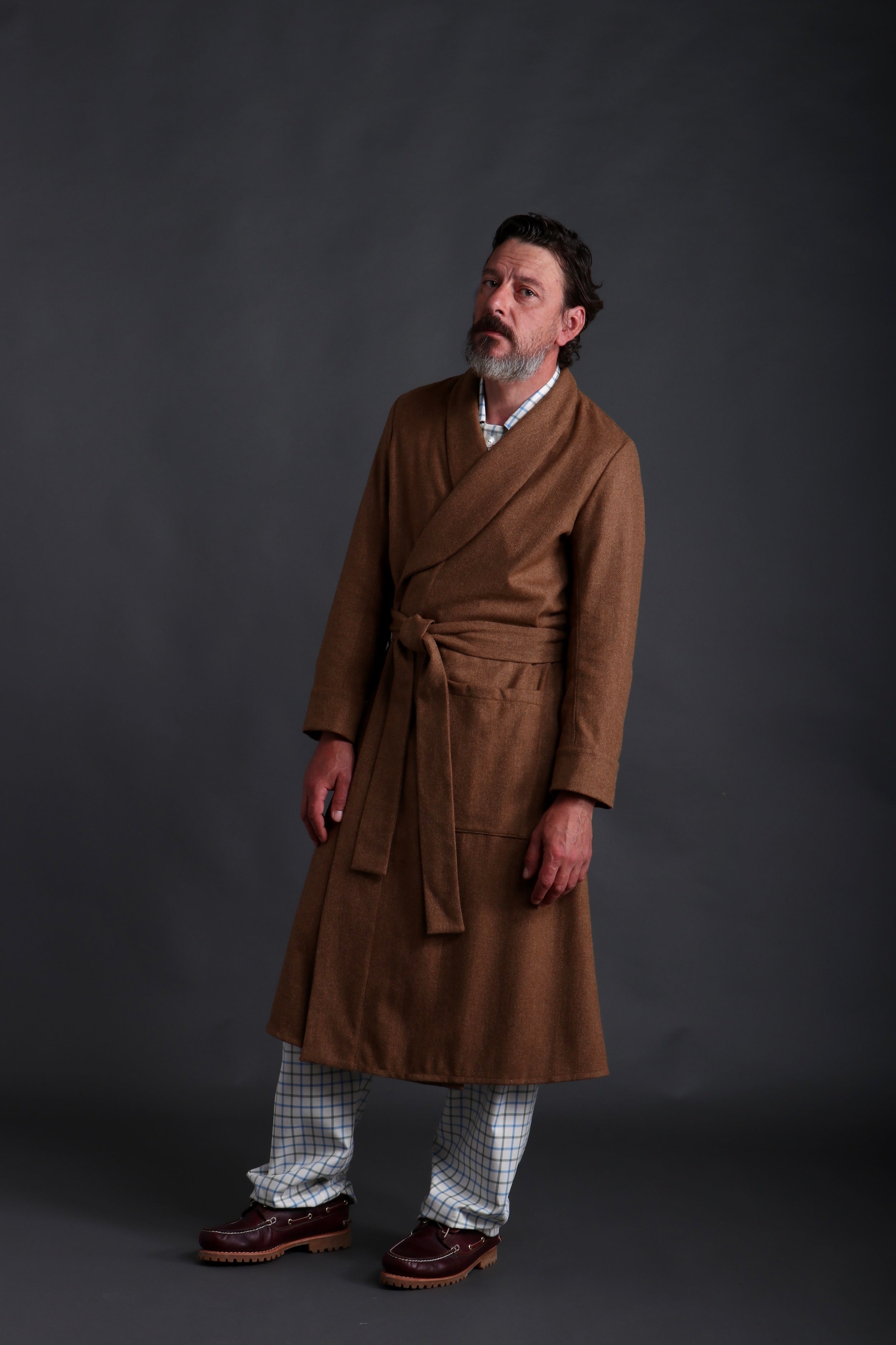 Man wears Carrier Company Wool Dressing Gown in Tan Herringbone