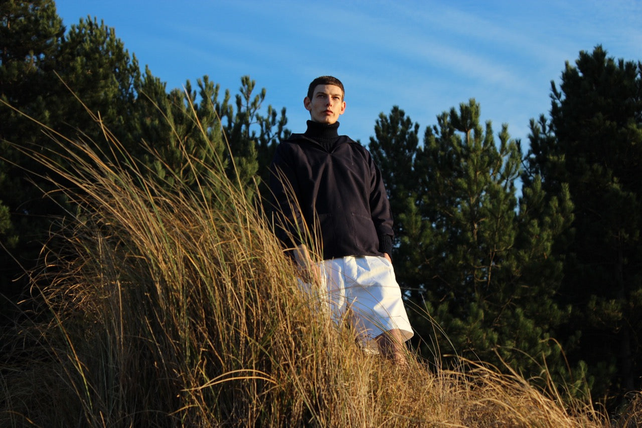 Man wearing Carrier Company Grandpa Short in White Cotton Drill and Navy W-Neck Smock