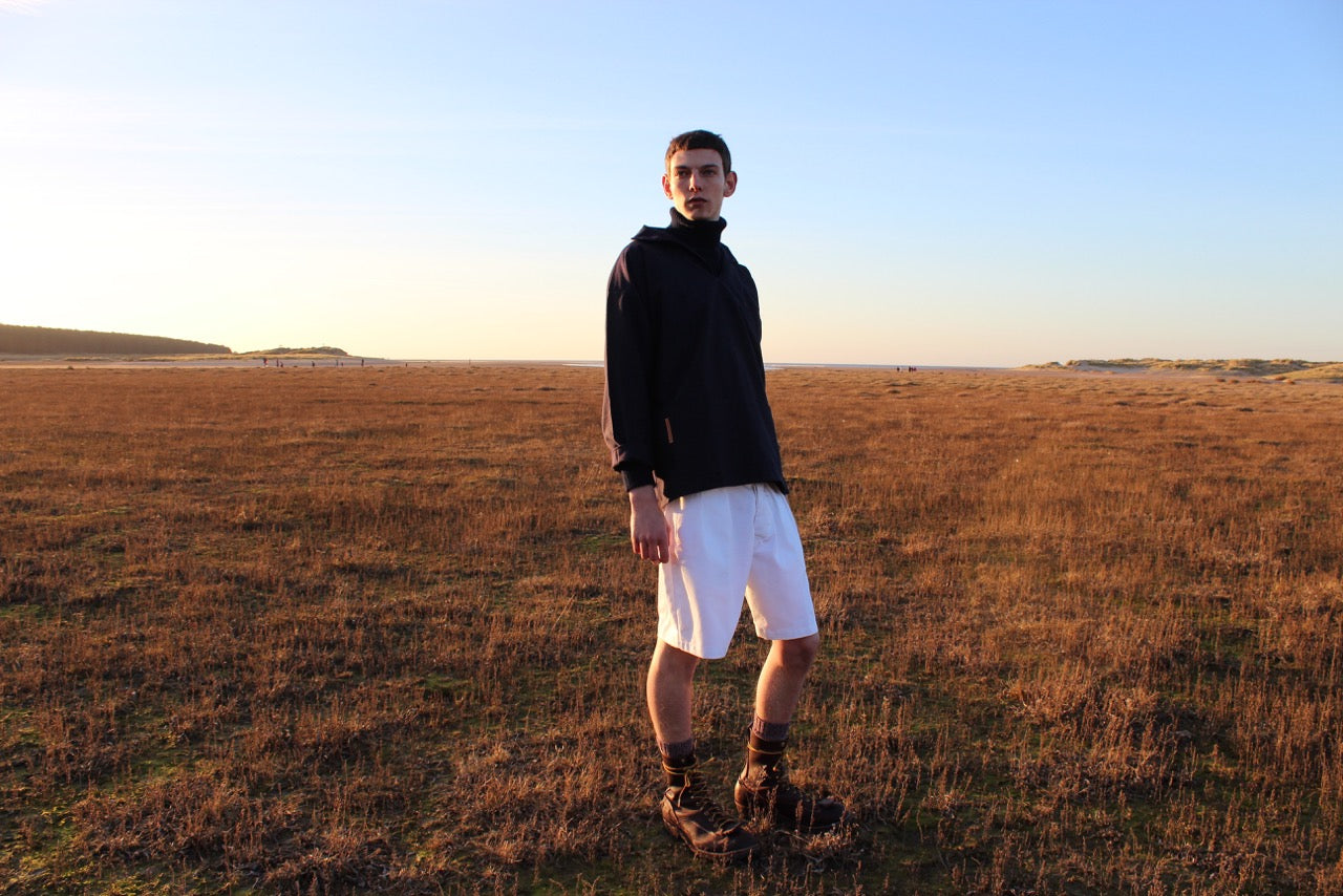 Man wearing Carrier Company Grandpa Short in White Cotton Drill and Navy V-Neck Smock with Navy Fisherman's Jumper