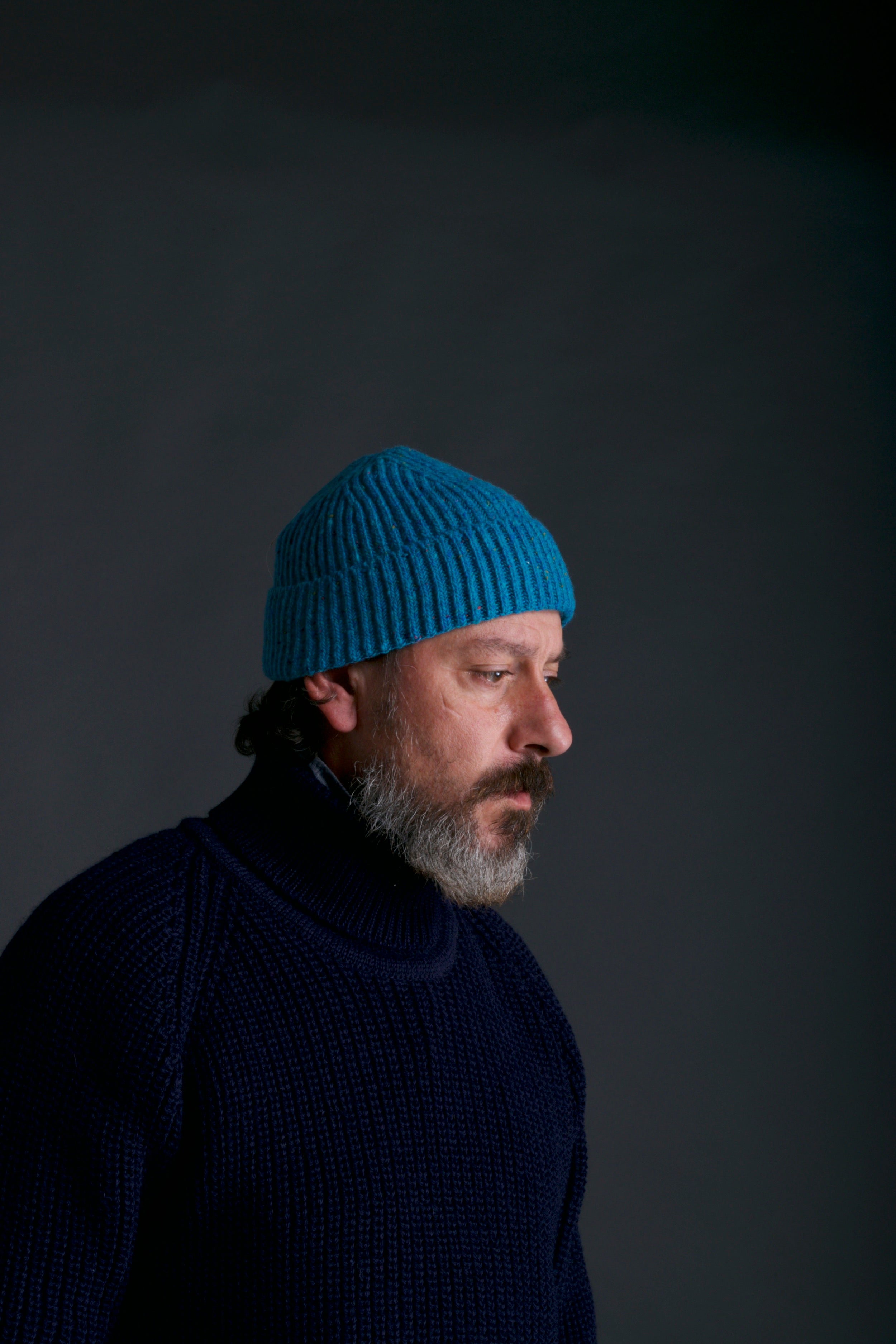 Man wears Carrier Company Donegal Wool Hat in Turquoise with Navy Fisherman's Jumper