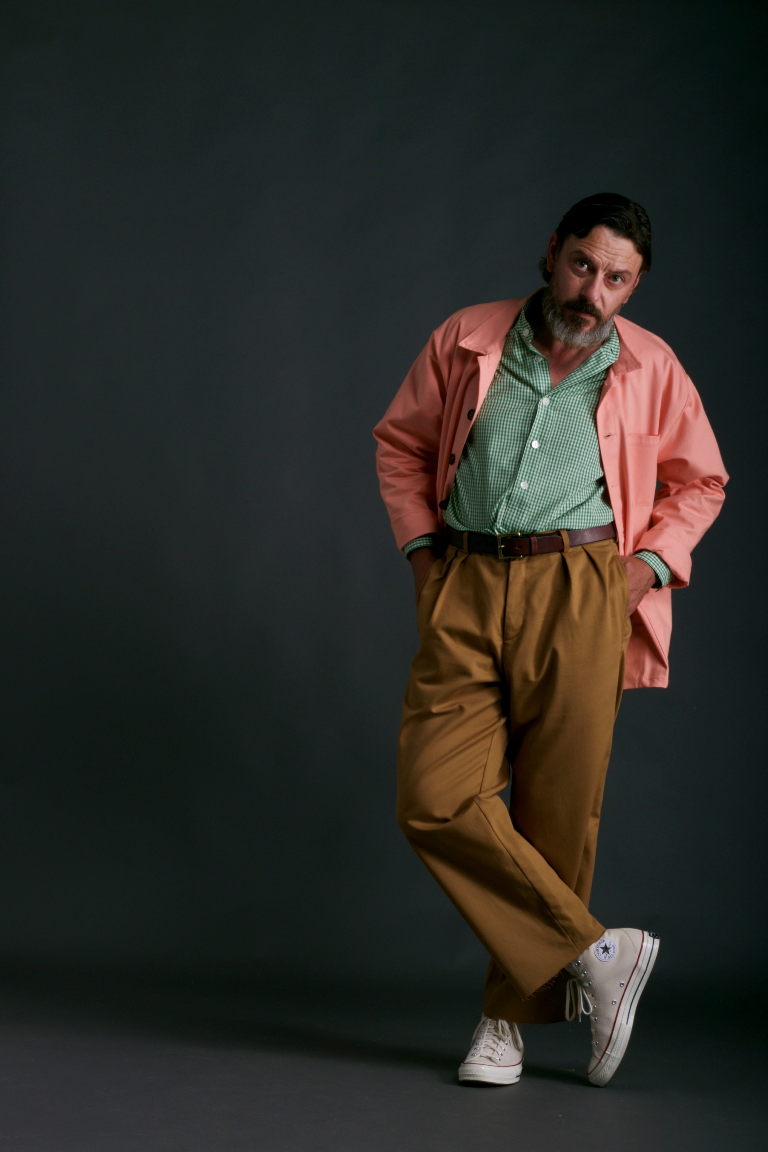 Man wears Carrier Company Classic Trouser in Tan, Collarless Green Gingham Shirt and Panama Sailcloth Jacket in Cantaloupe.