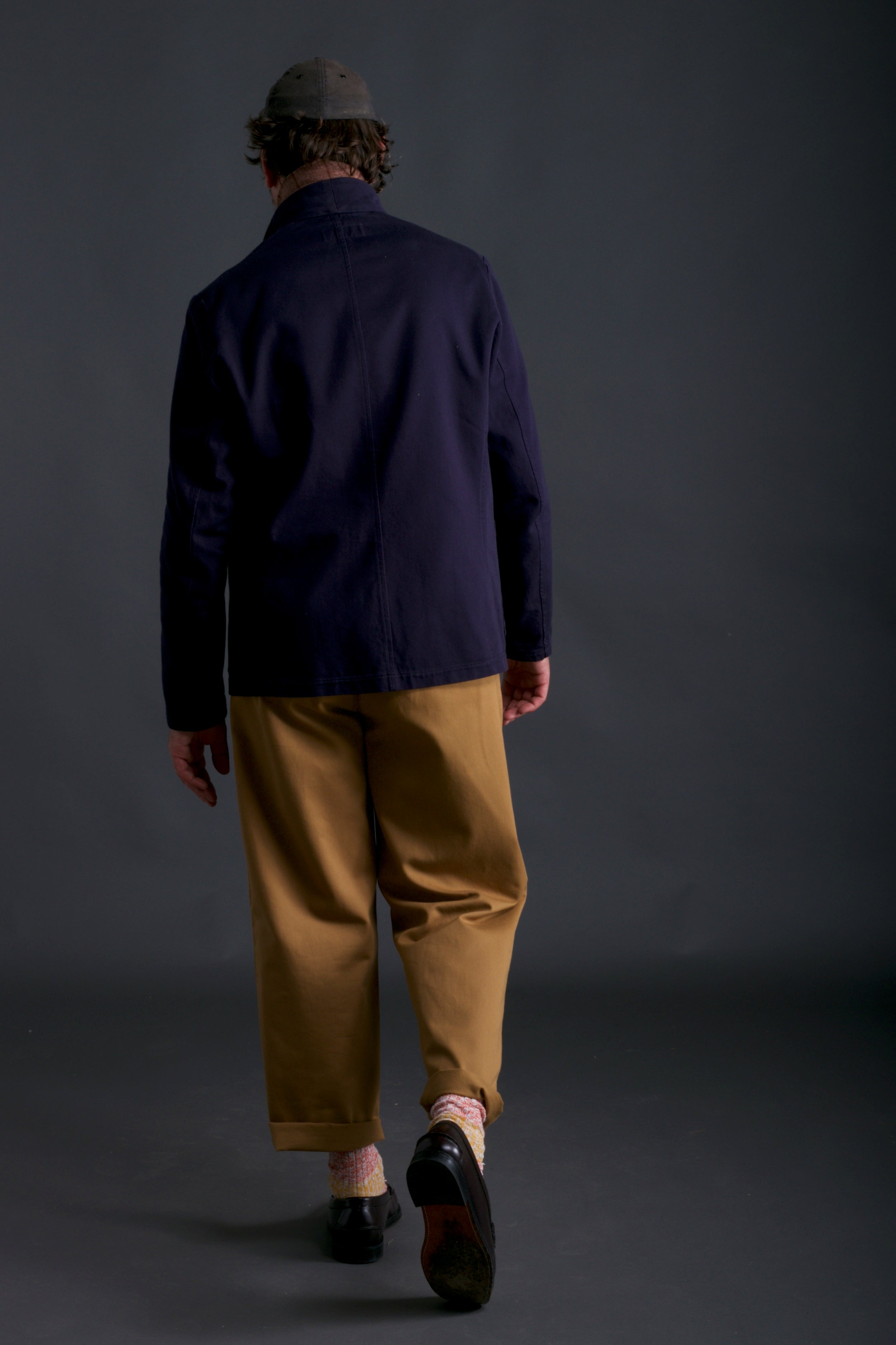 Man wears Carrier Company Classic Trouser in Tan, Three Button Jacket in Navy and Salmon Wool Walking Socks