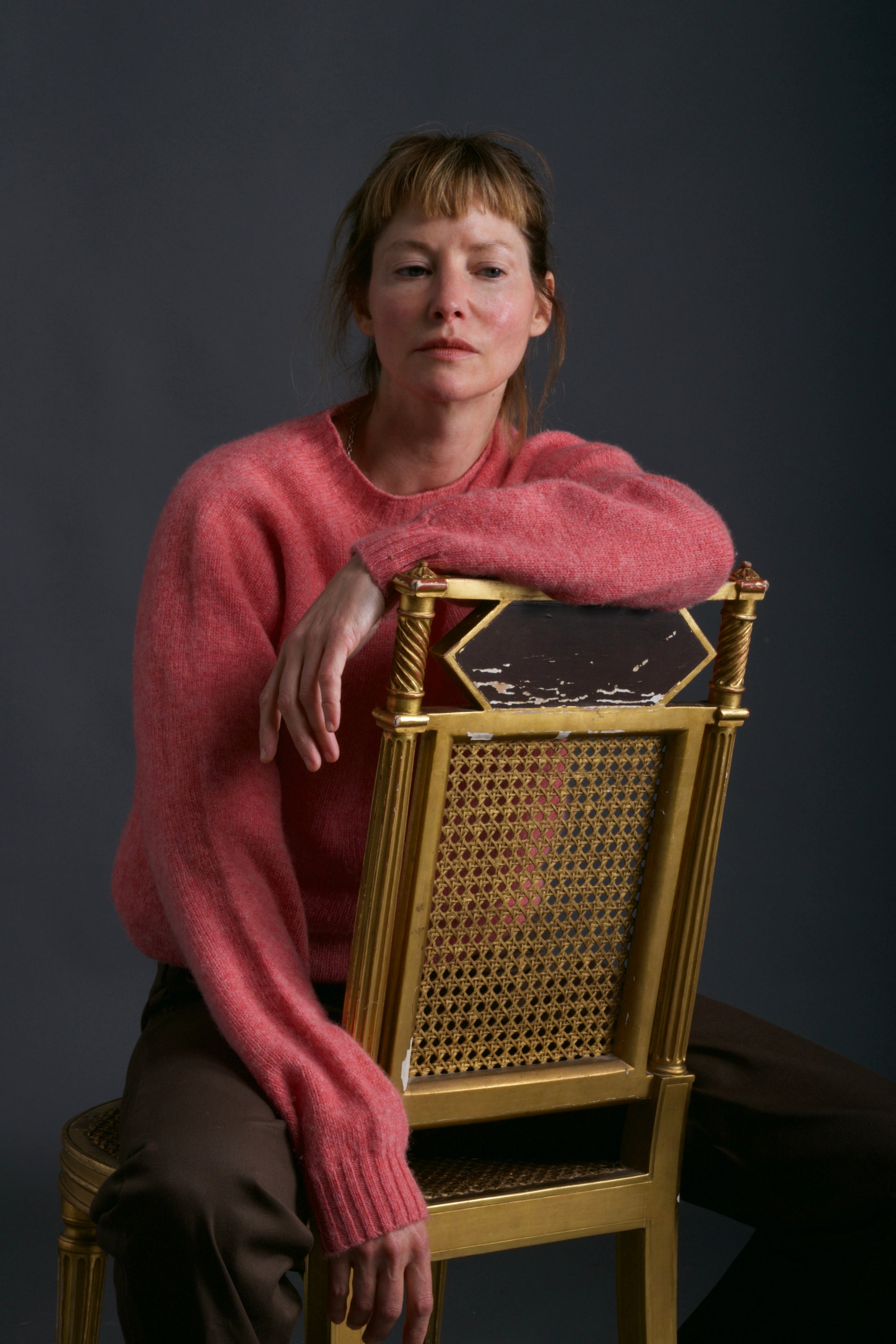 Woman wears Carrier Company Shetland Lambswool Jumper in Salmon