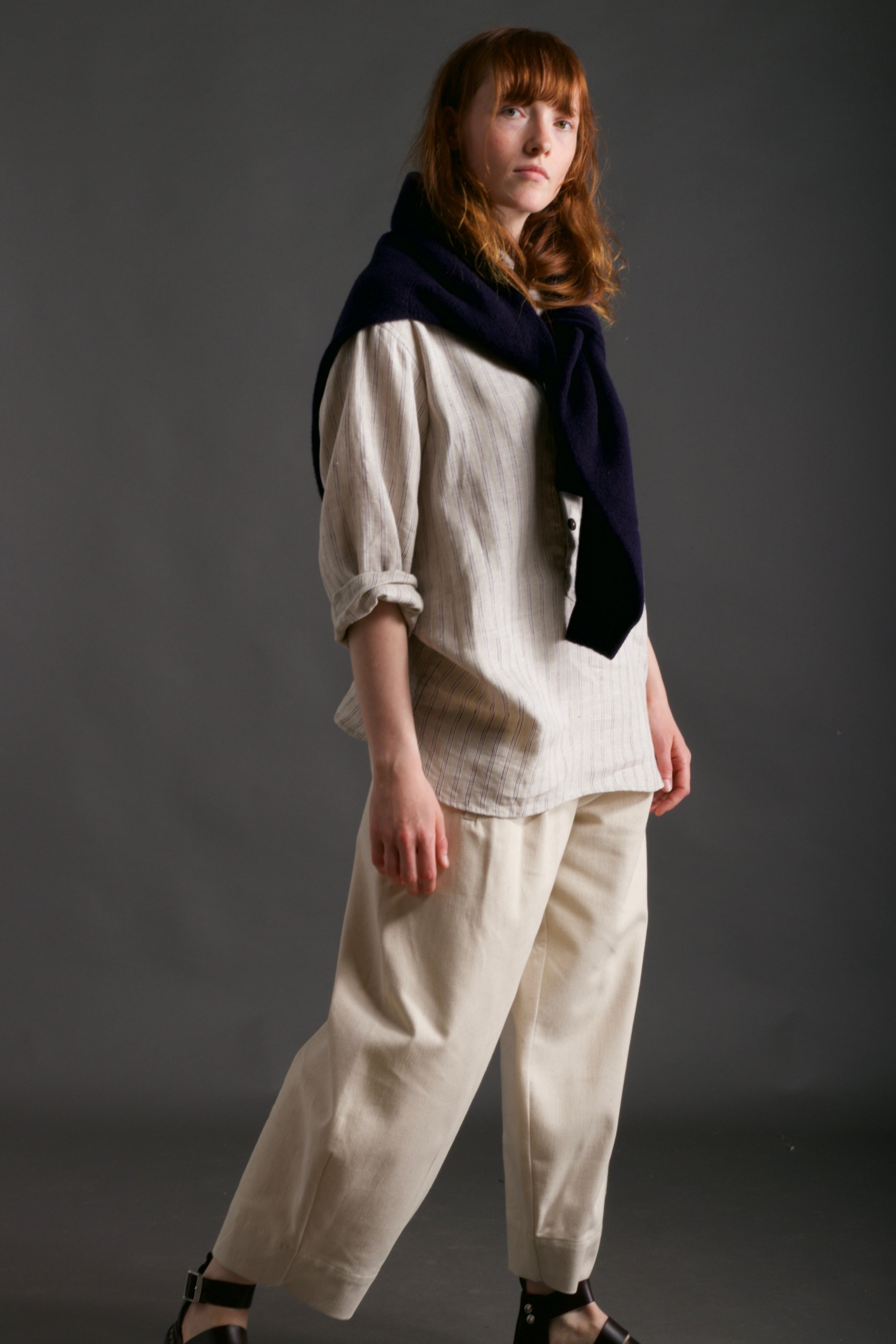 Woman wears Carrier Company Shetland Lambswool Jumper in Navy with Dutch Trouser in Seeded Denim and Linen Collarless Work Shirt