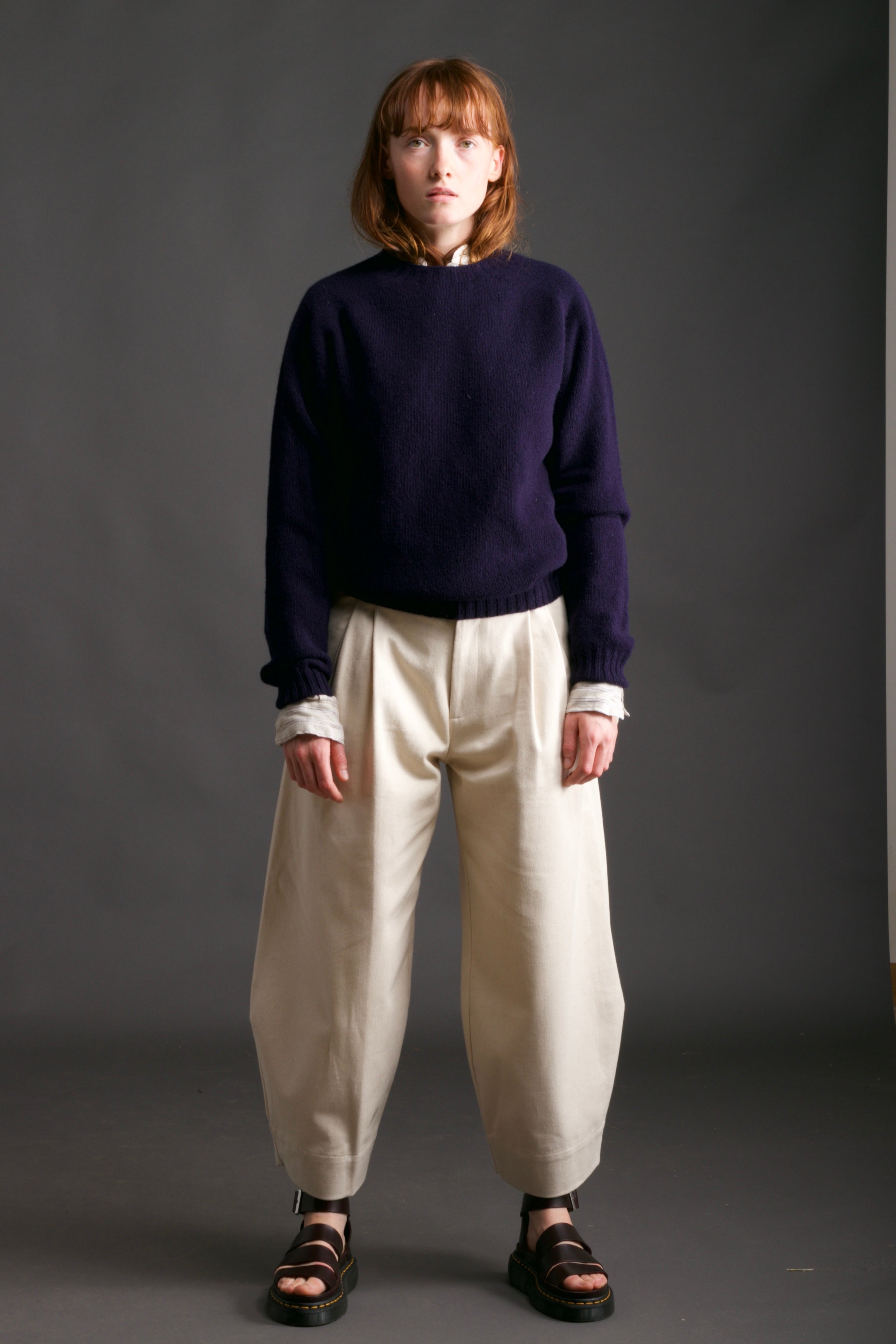 Woman wears Carrier Company Shetland Lambswool Jumper in Navy with Dutch Trouser in Seeded Denim