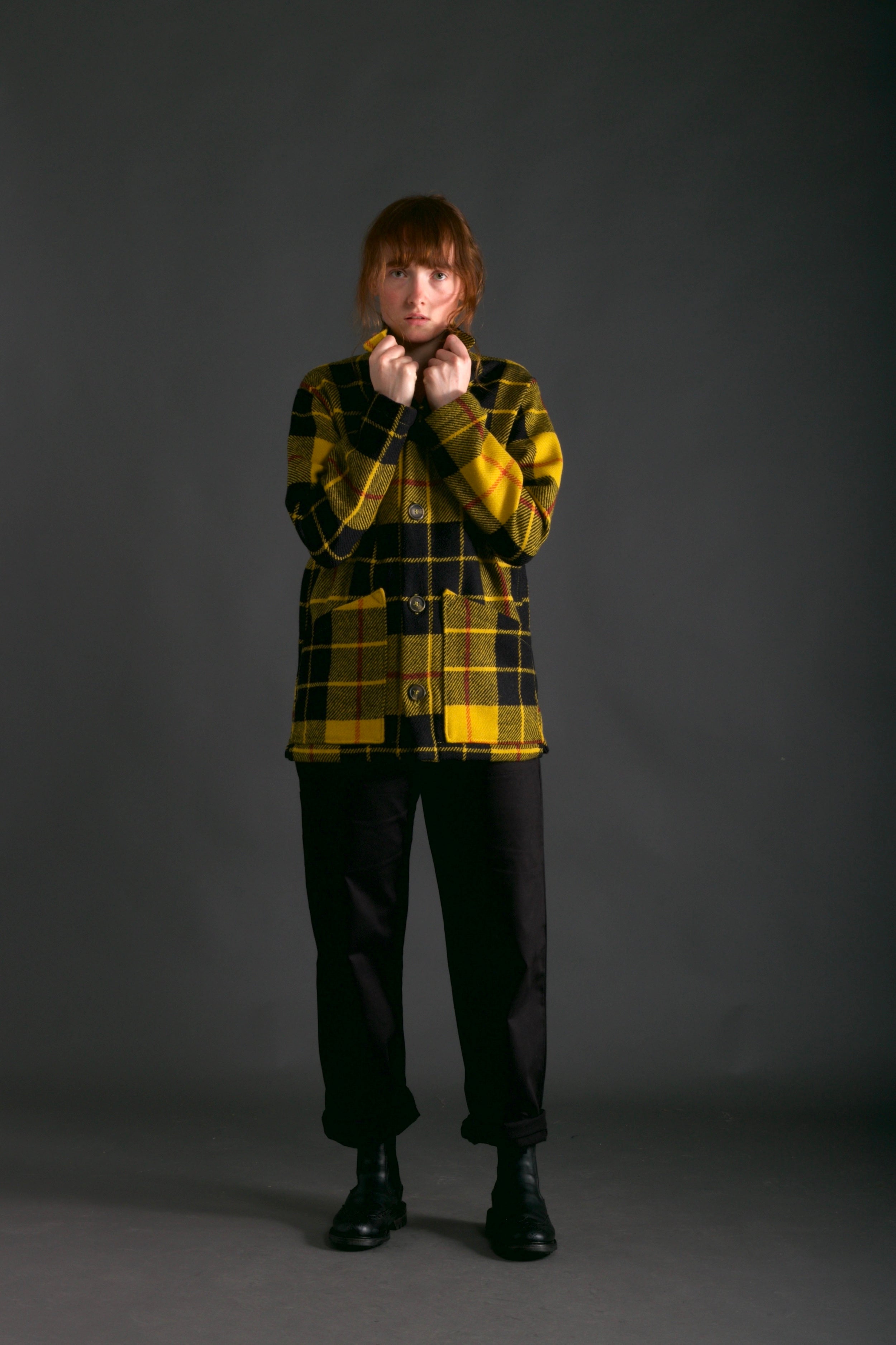 Woman wears Carrier Company Celtic Wool Jacket in Black and Yellow with Women's Dungarees in Black