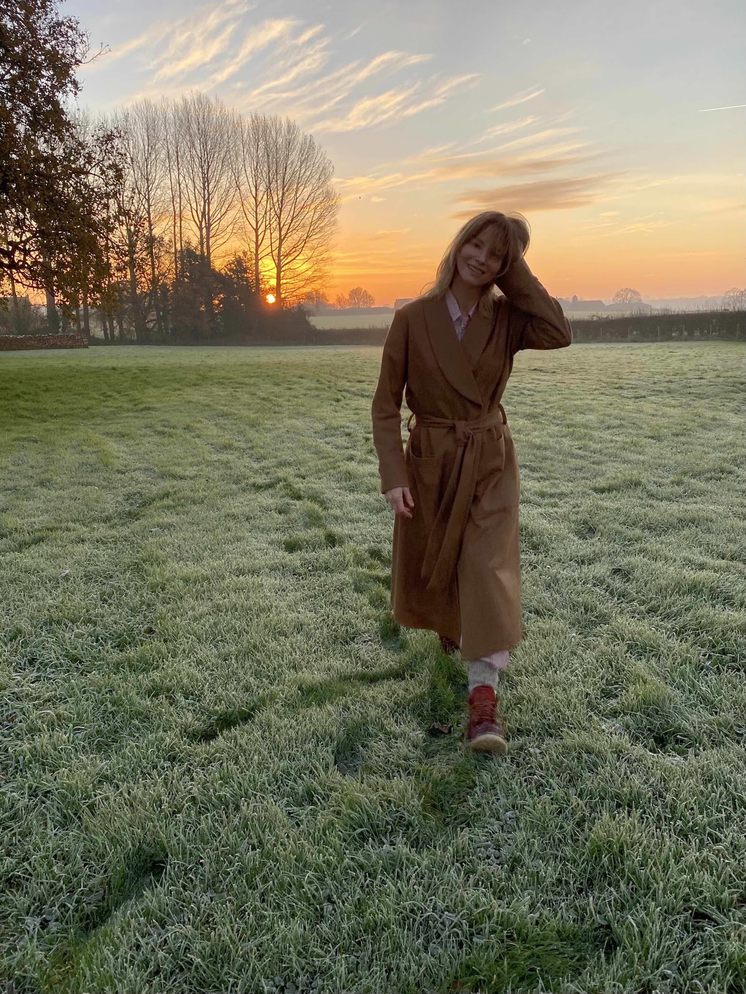 Woman wearing Carrier Company Wool Dressing Gown in Tan Herringbone and Shetland Lambswool Jumper in Blaze