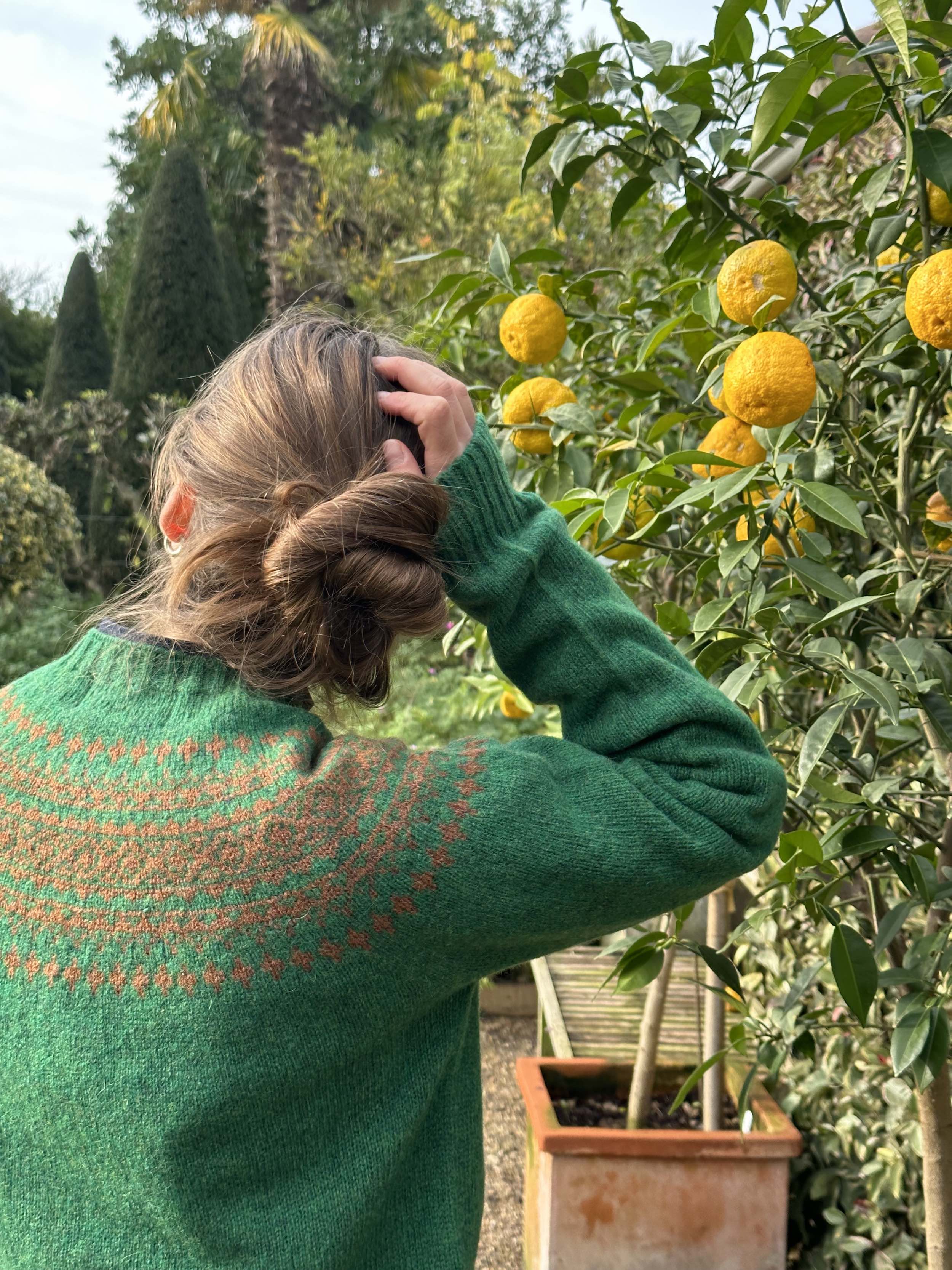 Sienna wears Carrier Company Shetland Lambswool Yoke Jumper in Emerald and Ember