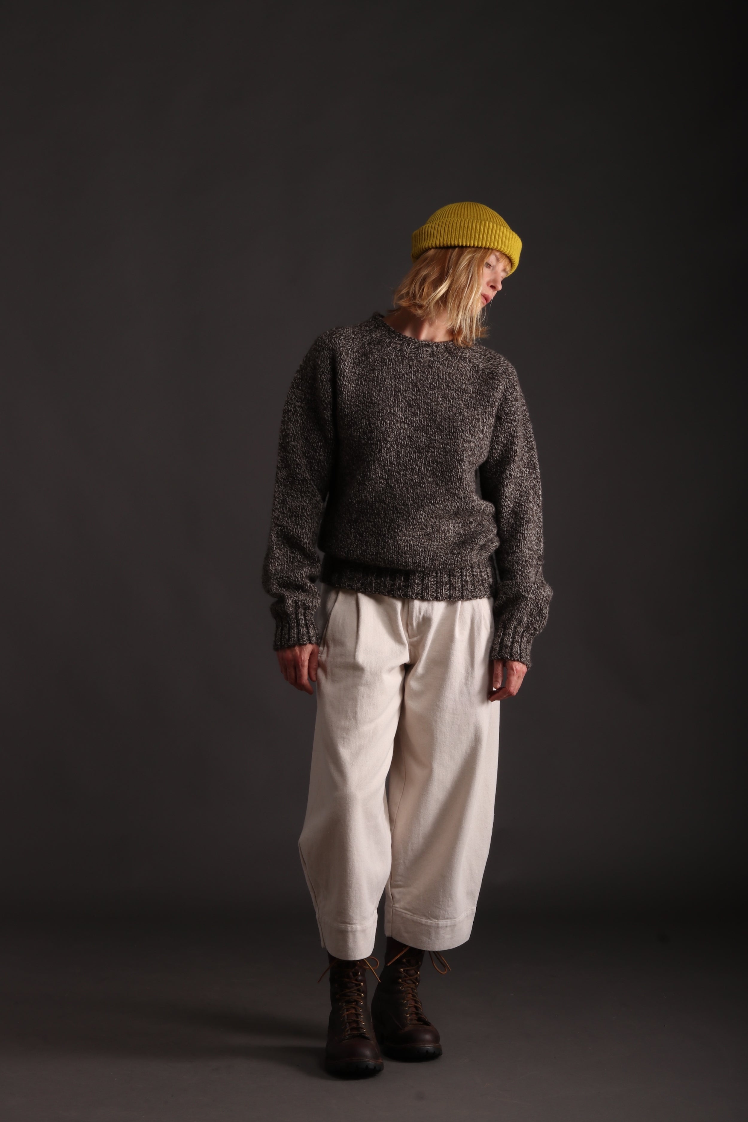 Woman wears Carrier Company Heavy Heritage Breed Lambswool Jumper with Wool Hat in Yellow and Dutch Trouser in Seeded Denim