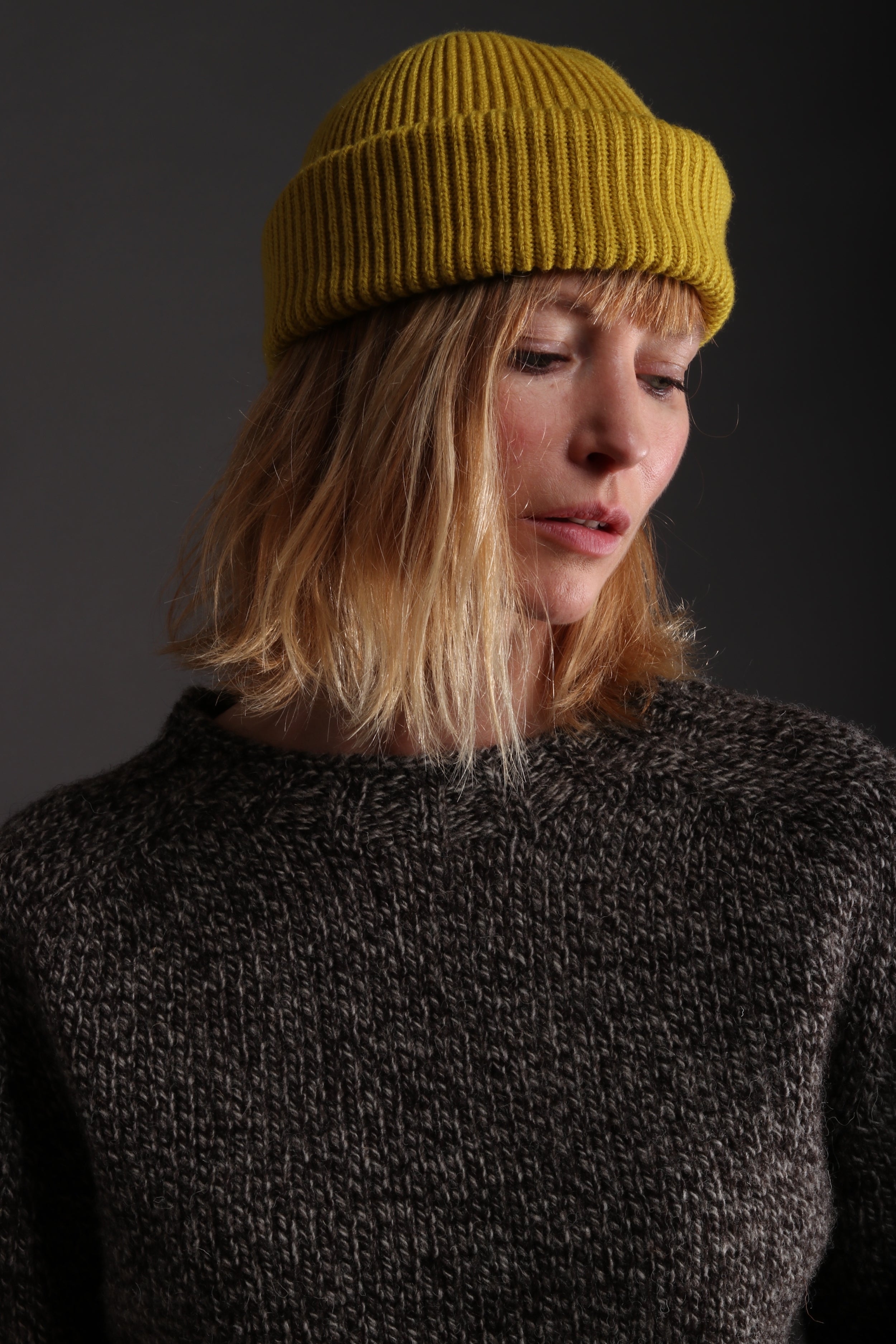 Woman wears Carrier Company Heavy Heritage Breed Lambswool Jumper with Wool Hat in Yellow and Dutch Trouser in Seeded Denim