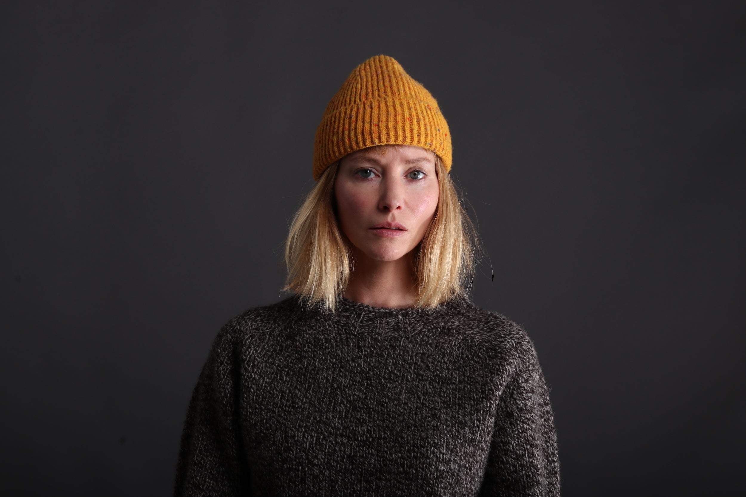 Woman wears Donegal Wool Hat in Papaya with Heavy Heritage Breed Lambswool Jumper