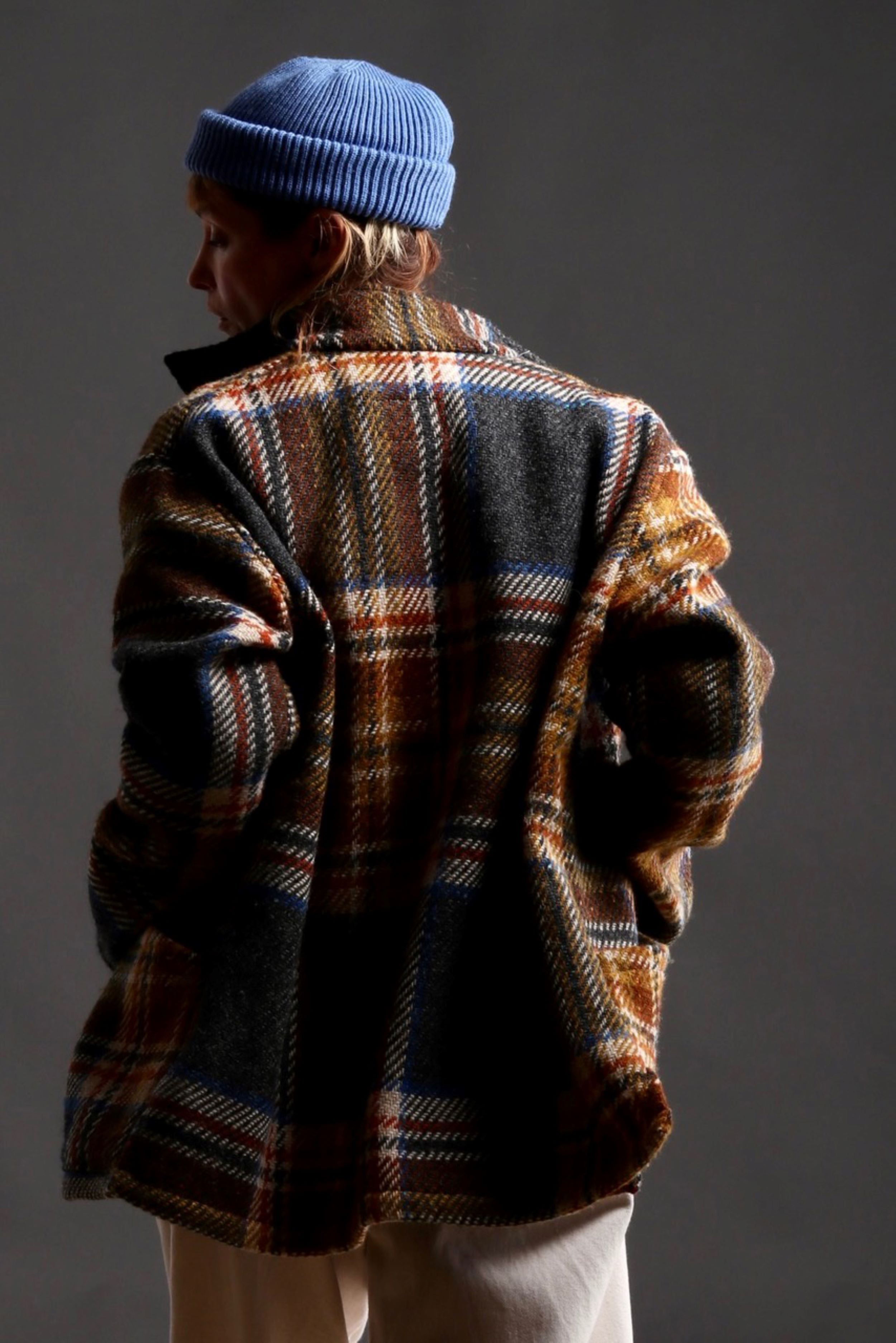 Woman wears Celtic Wool Jacket in Slate with Seeded Denim Dutch Trouser, Womens Waistcoat in Brown Wool, Collarless Work Shirt in Striped Linen and Merino Wool Hat in Sky Blue