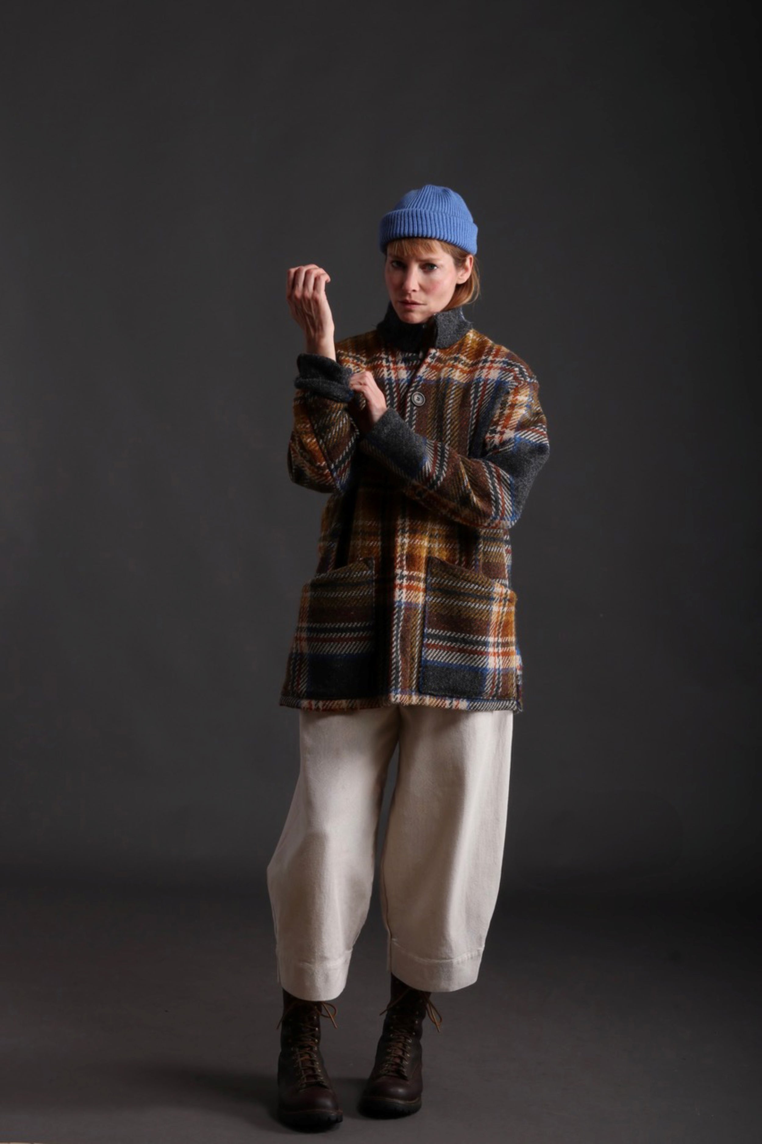 Woman wears Celtic Wool Jacket in Slate with Seeded Denim Dutch Trouser, Womens Waistcoat in Brown Wool, Collarless Work Shirt in Striped Linen and Merino Wool Hat in Sky Blue