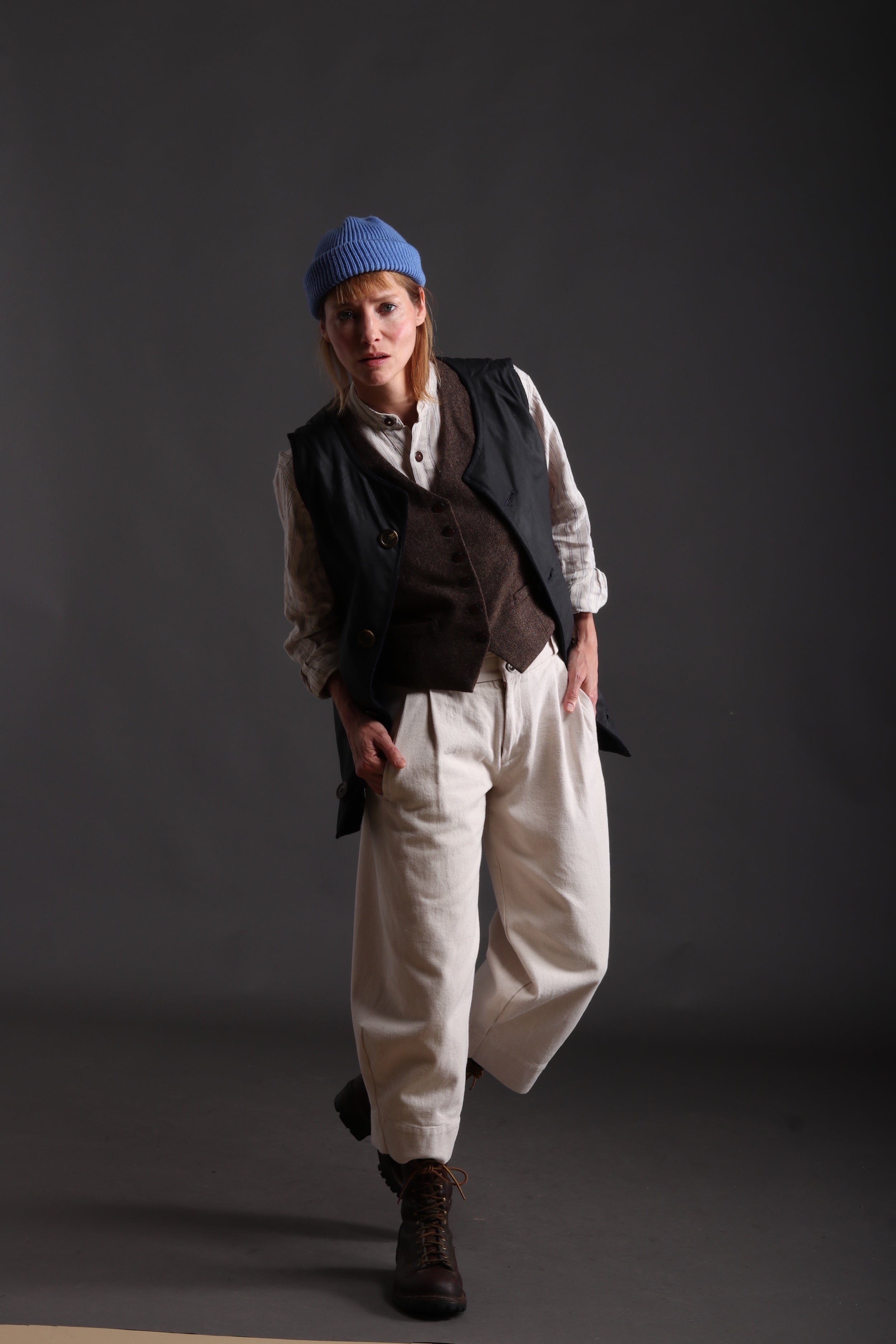 Sienna wears Carrier Company Wax Cotton Jerkin with linen collarless Work Shirt, Dutch Trouser in Seeded Denim and Wool Hat in Sky