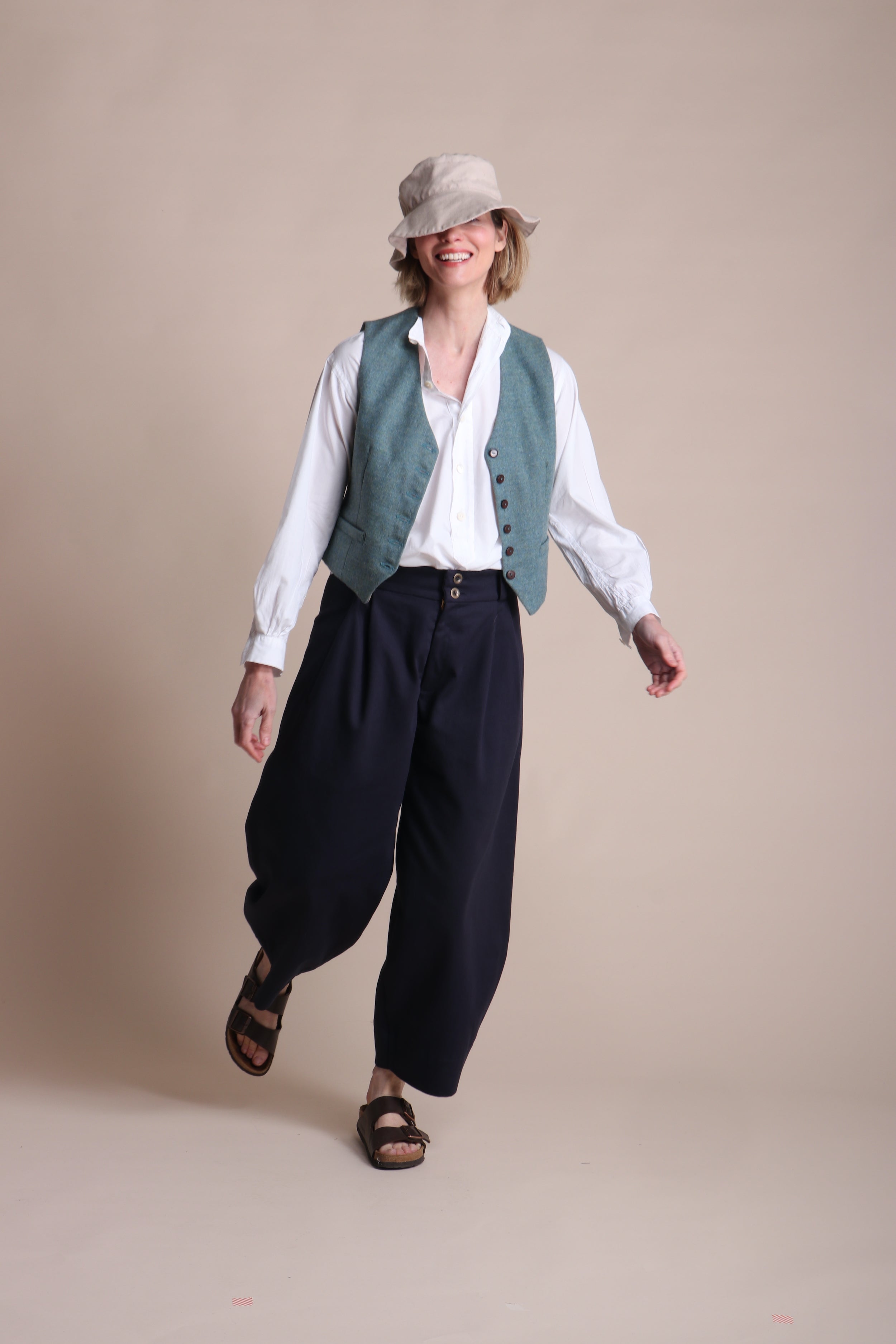 Woman wearing Carrier Company Dutch trouser In Navy Cotton Drill, Lightweight Collarless Shirt & Men's Wool Waistcoat