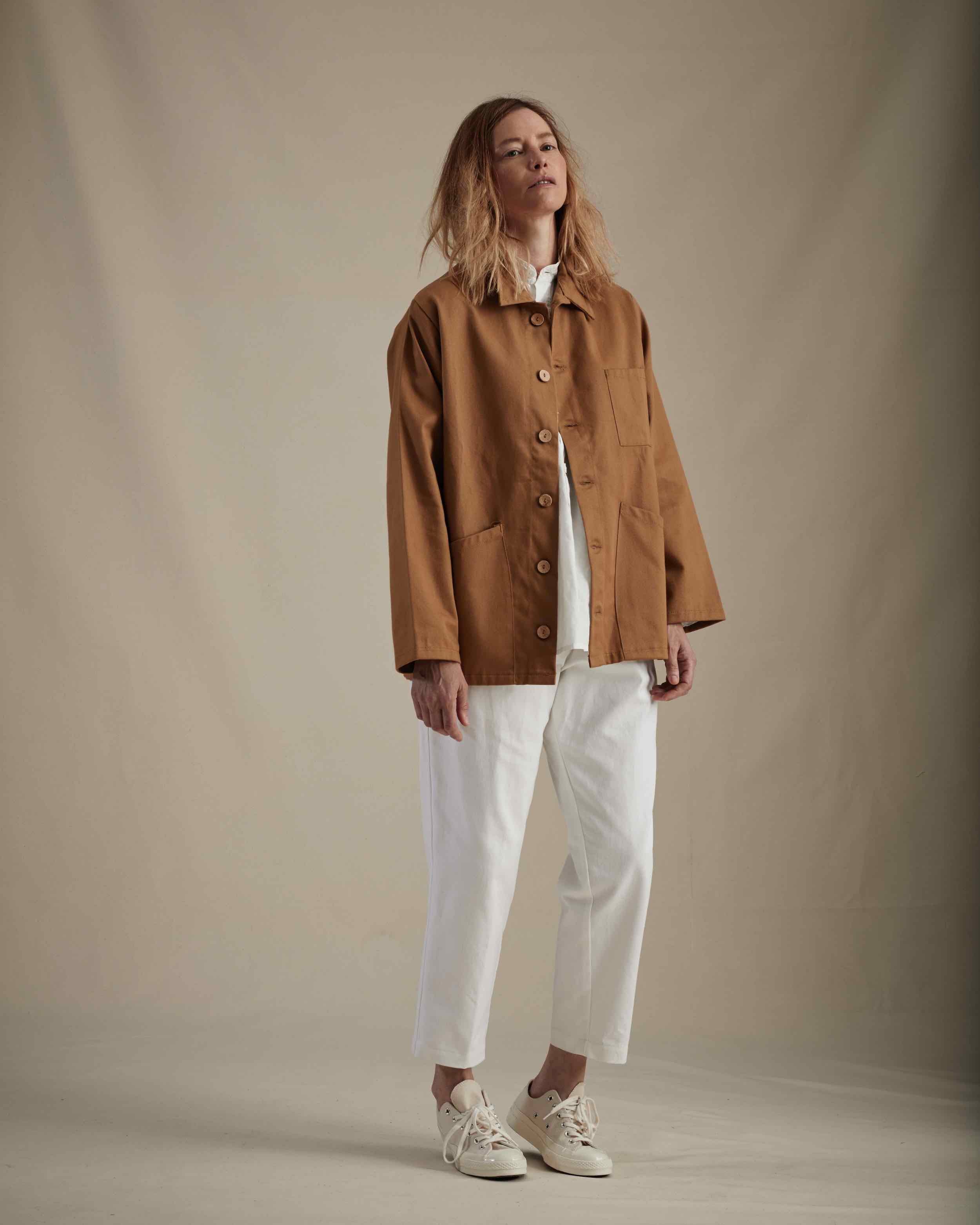 Woman wears Carrier Company Cropped Trouser in White and Norfolk Work Jacket in Tan
