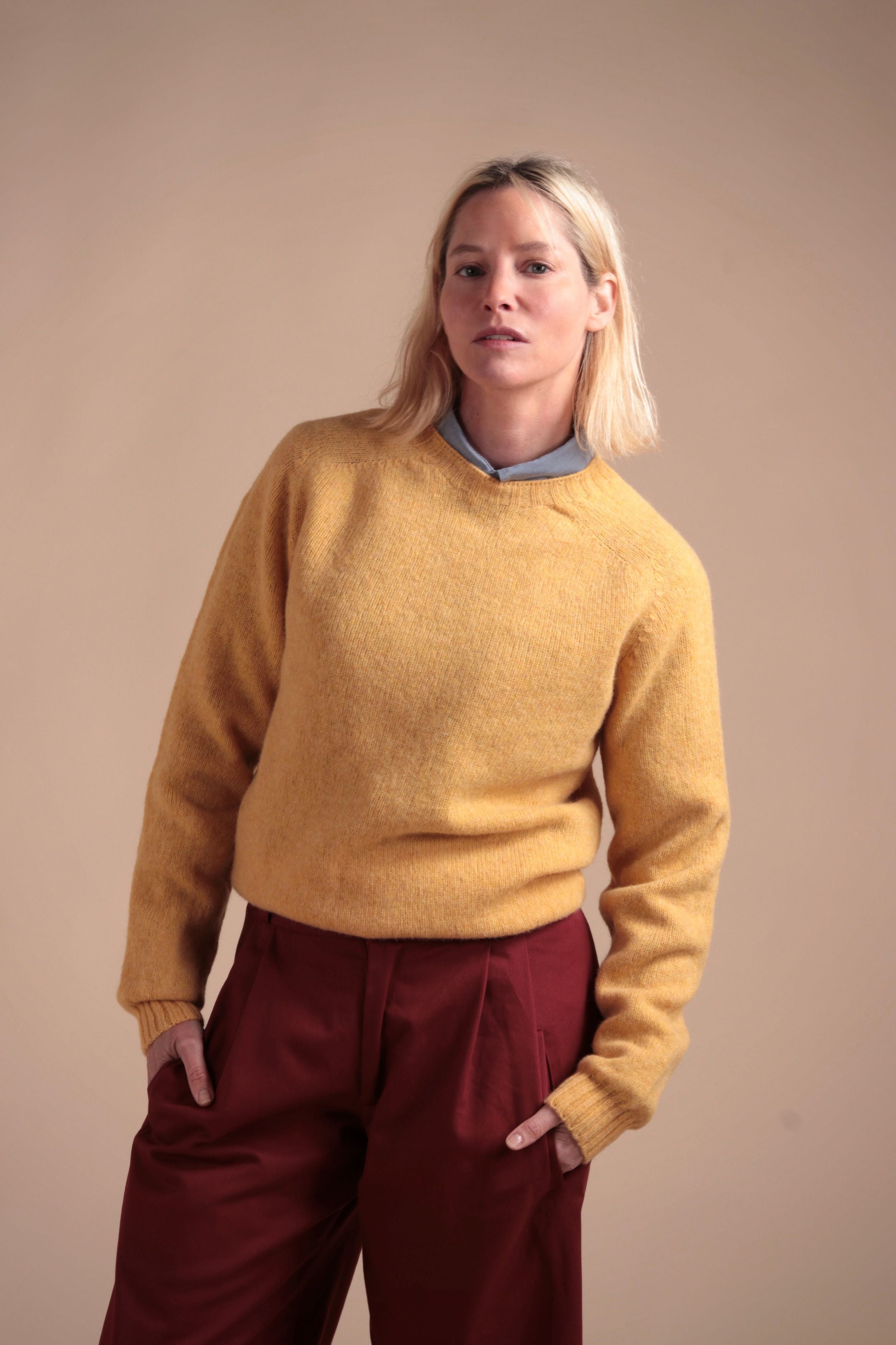 Woman wearing Carrier Company Shetland Lambswool Jumper in Chamomile with Breton Red Dutch Trouser in Cotton Drill