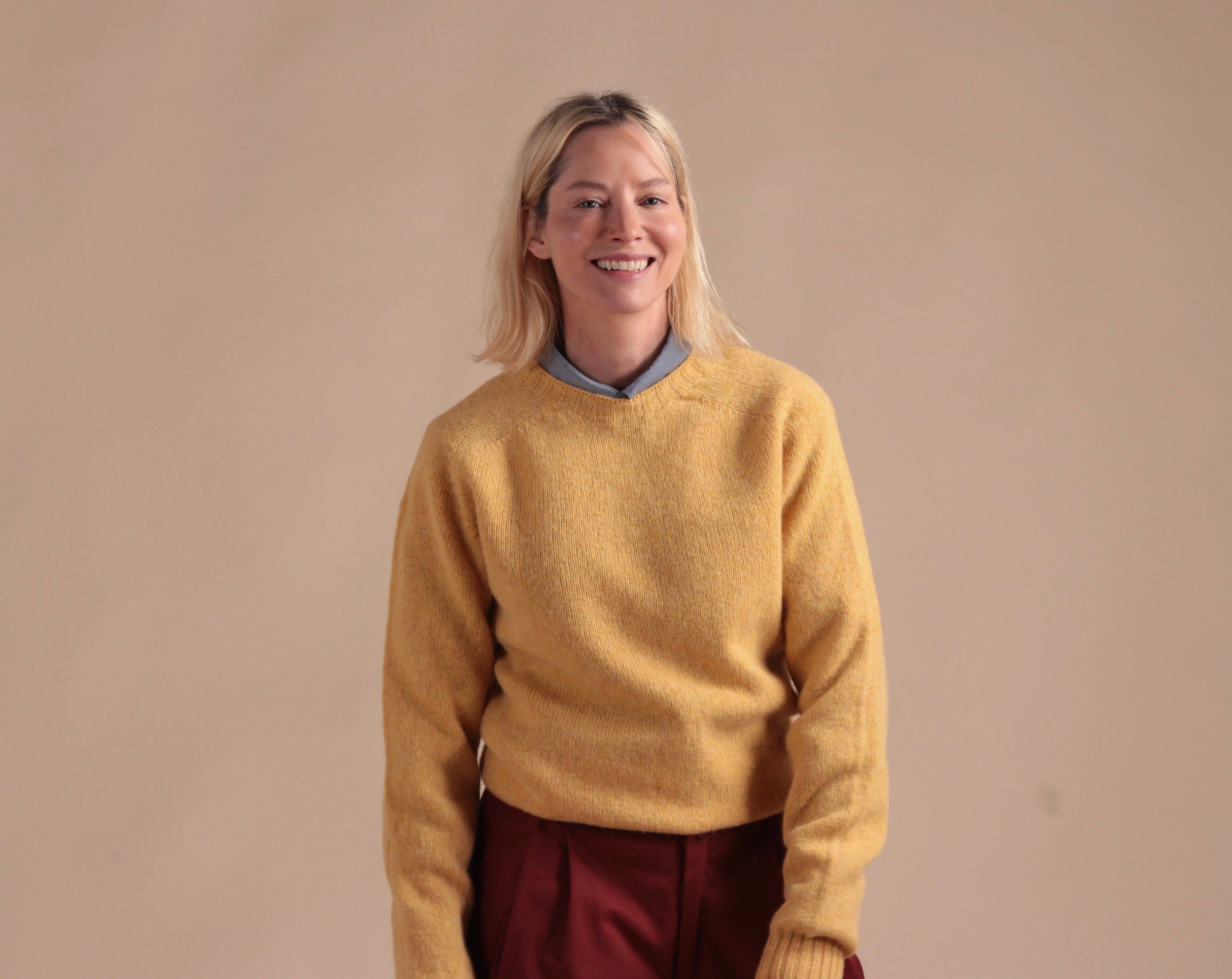 Woman wearing Carrier Company Shetland Lambswool Jumper in Chamomile with Breton Red Dutch Trouser in Cotton Drill