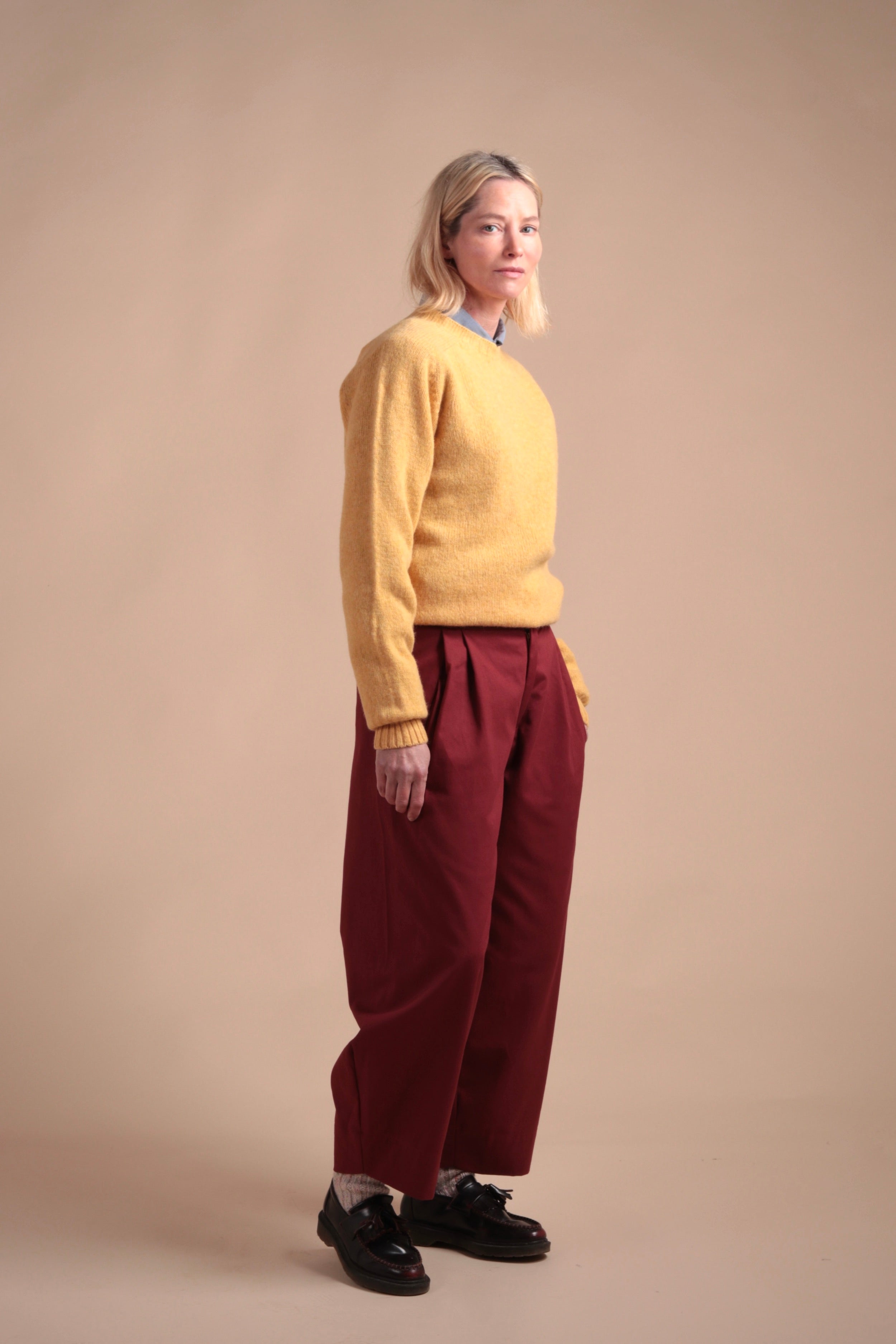 Woman wearing Carrier Company Shetland Lambswool Jumper in Chamomile with Breton Red Dutch Trouser in Cotton Drill