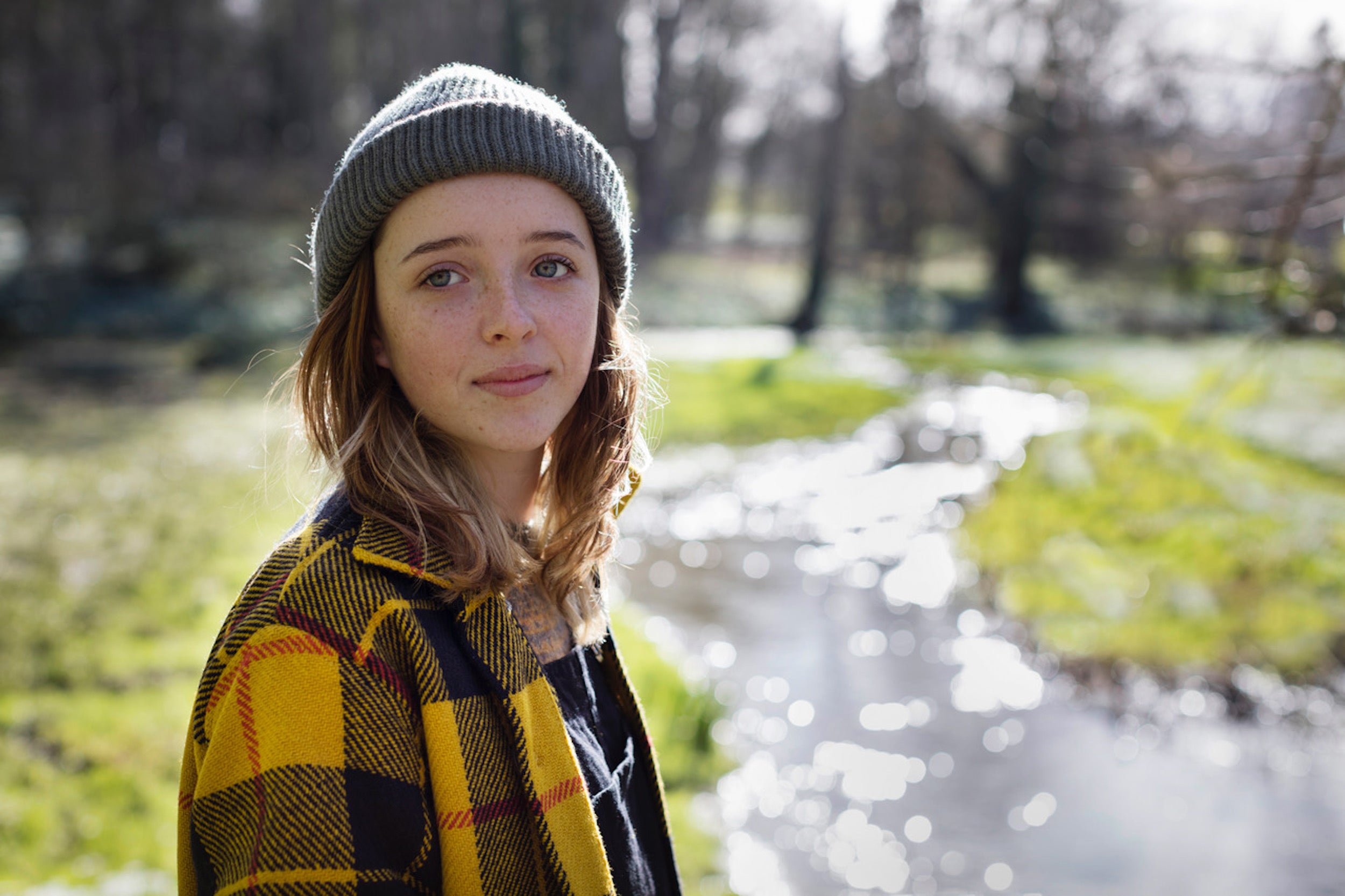 Woman in barn wearing Carrier Company Celtic Wool Jacket in Black and Yellow Check with Wool Hat