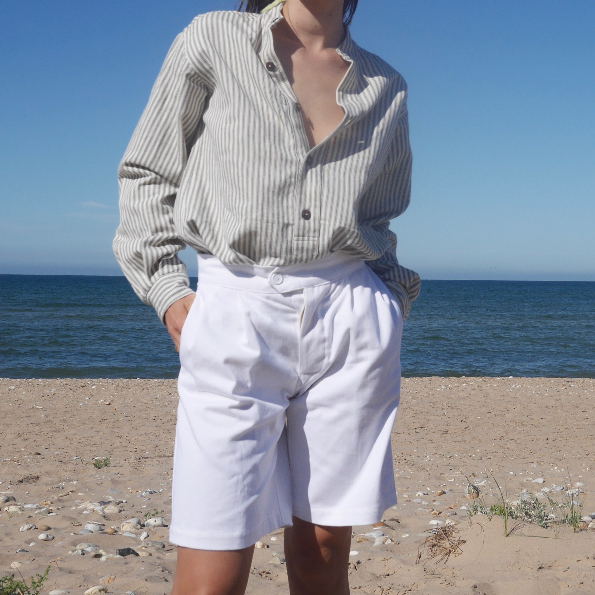 Woman wears Carrier Company Collarless Workshirt in Indigo Ticking and Women's Shorts in White