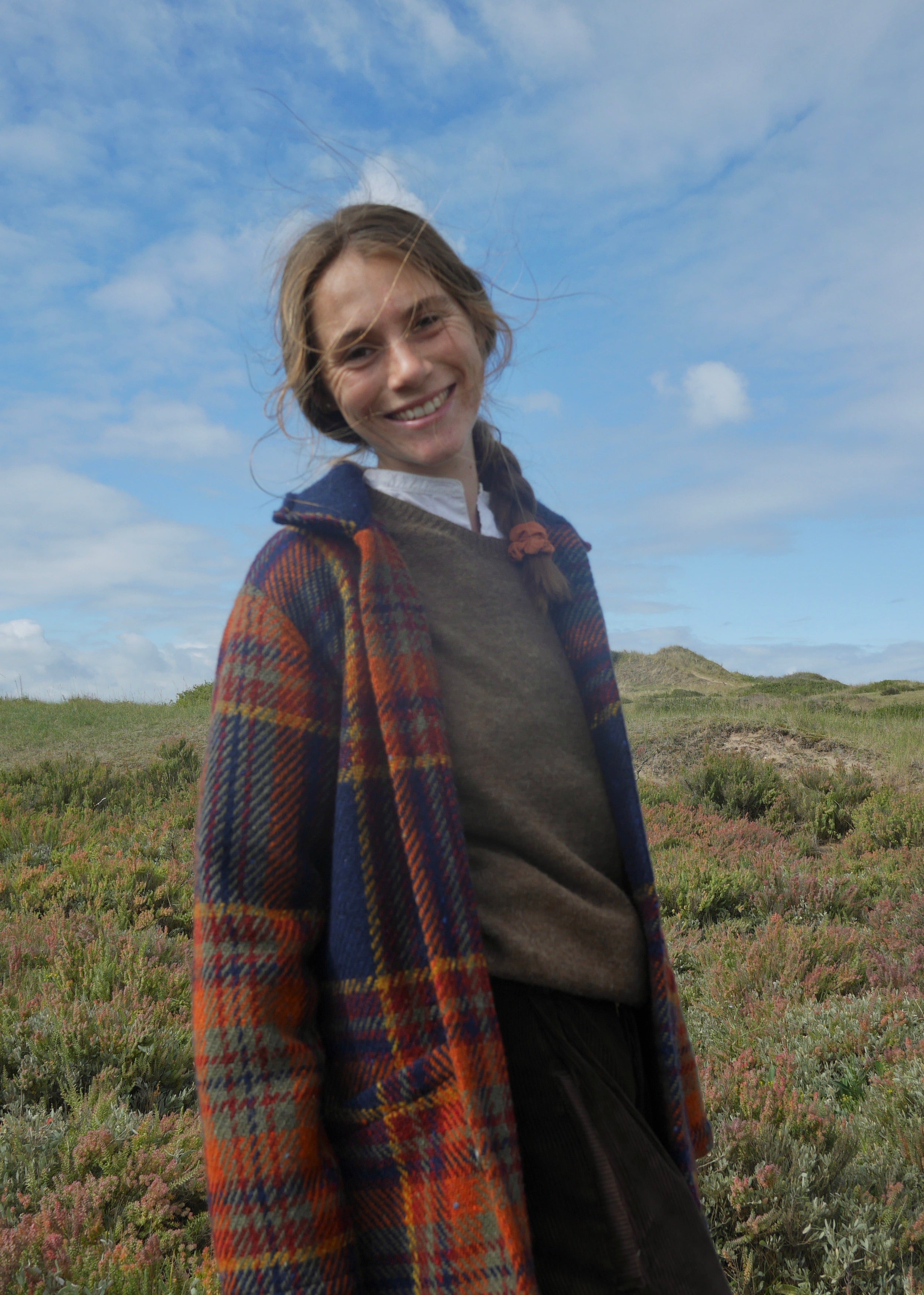 Woman wears Carrier Company Celtic Wool Jacket in Navy and Rust with Shetland Lambswool Jumper and Dutch Trouser in Corduroy