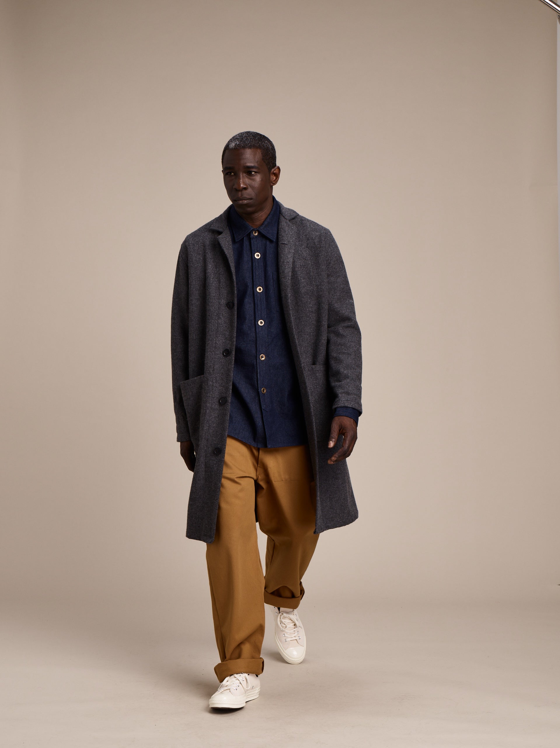 Man wearing Carrier Company Men's Work Trouser in Tan Drill with Grey Wool Coat and Denim Collar Shirt