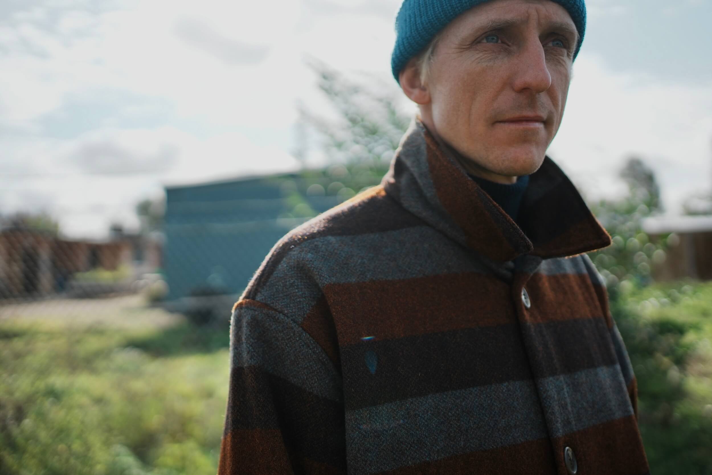 Tommy Wears Carrier Company Yorkshire Wool Jacket In Conker Stripe WIth Merino Wool Jumper, Wool Watch Cap & Men's Work Trouser in Tan