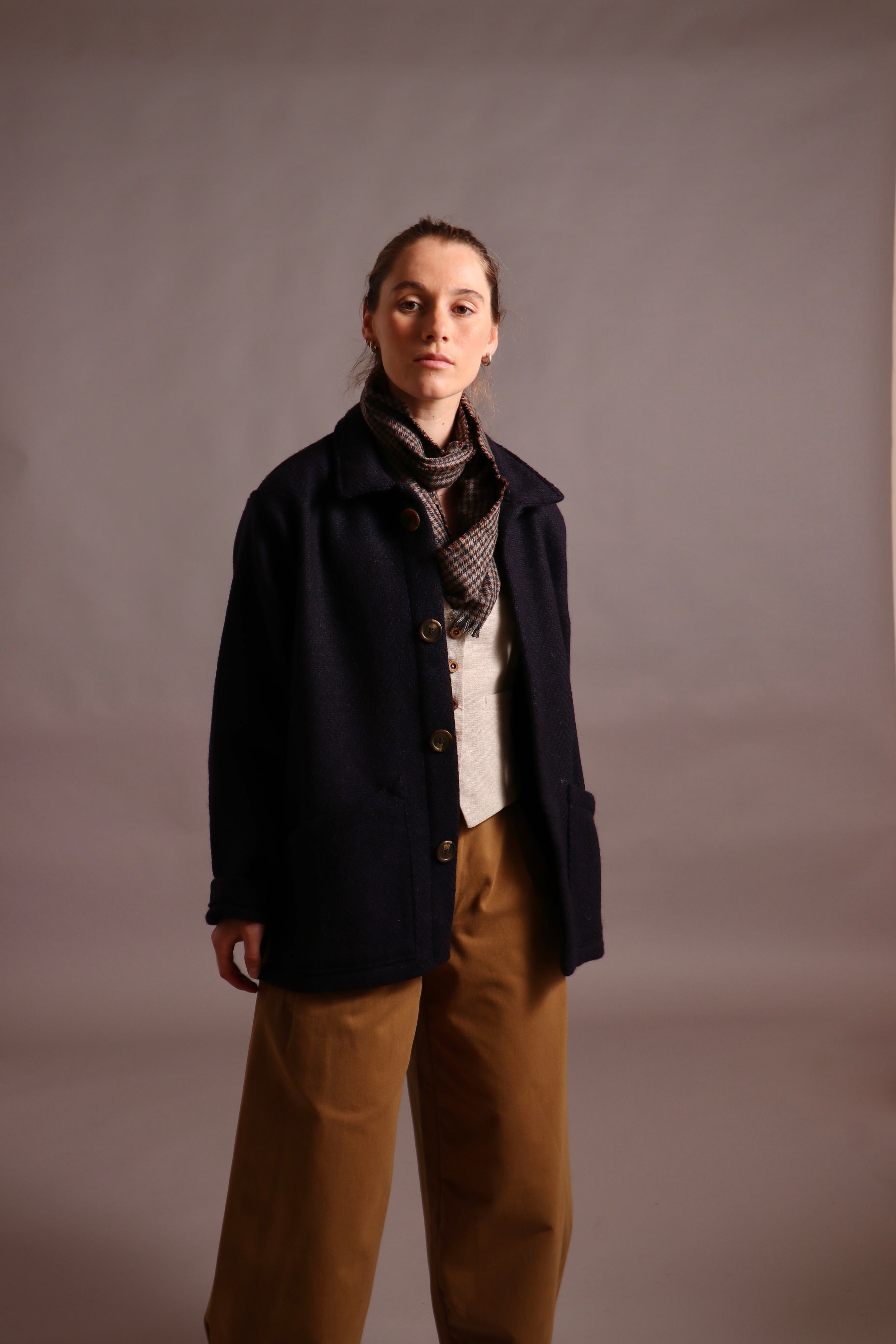 Decca wears Carrier Company Celtic Wool Jacket with Dutch trouser in Tan Cotton Drill, Wool Waistcoat and Scarf
