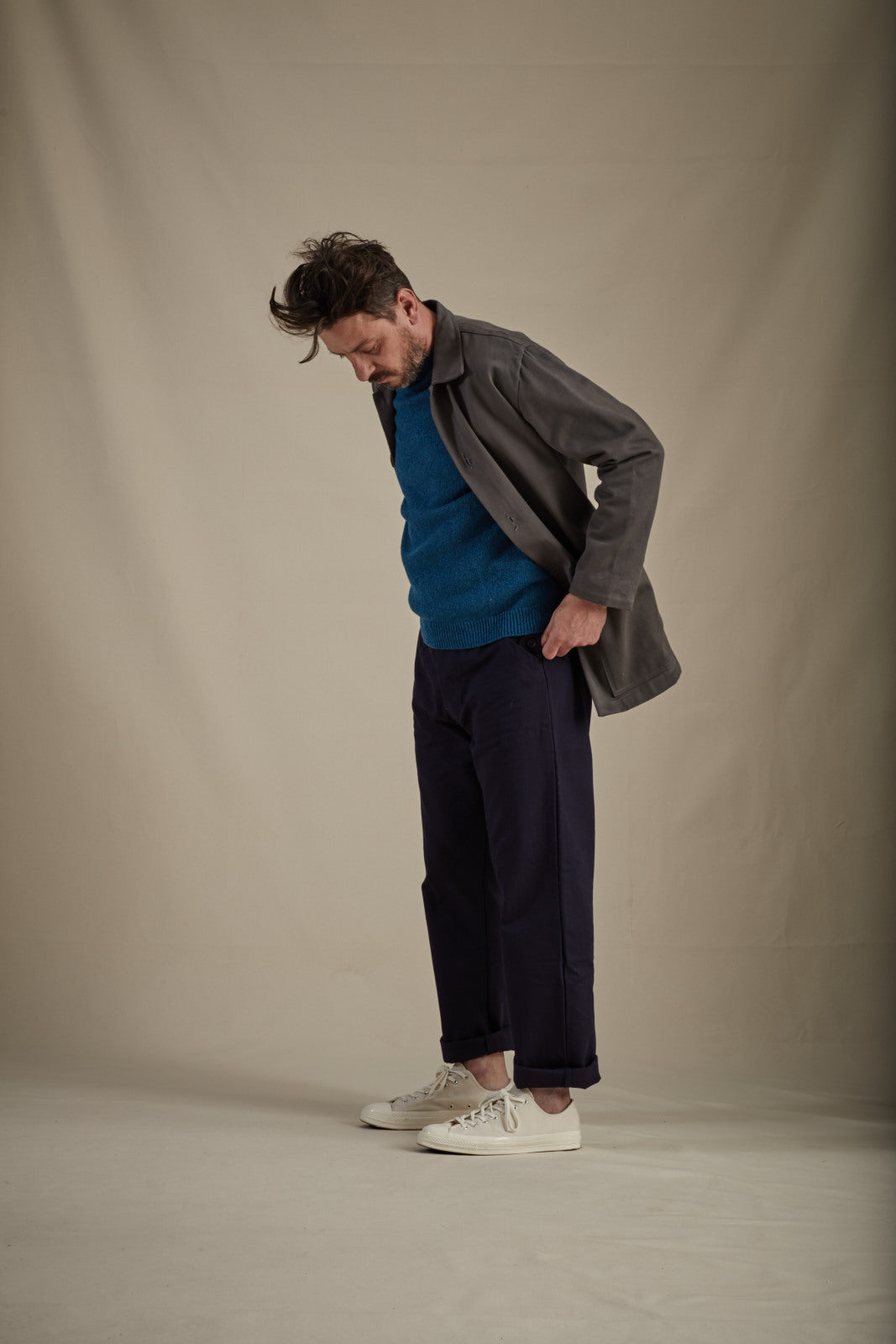Man wearing Carrier Company Men's Work Trouser in Navy with Shetland Lambswool Jumper in Cyan and Draught Jacket